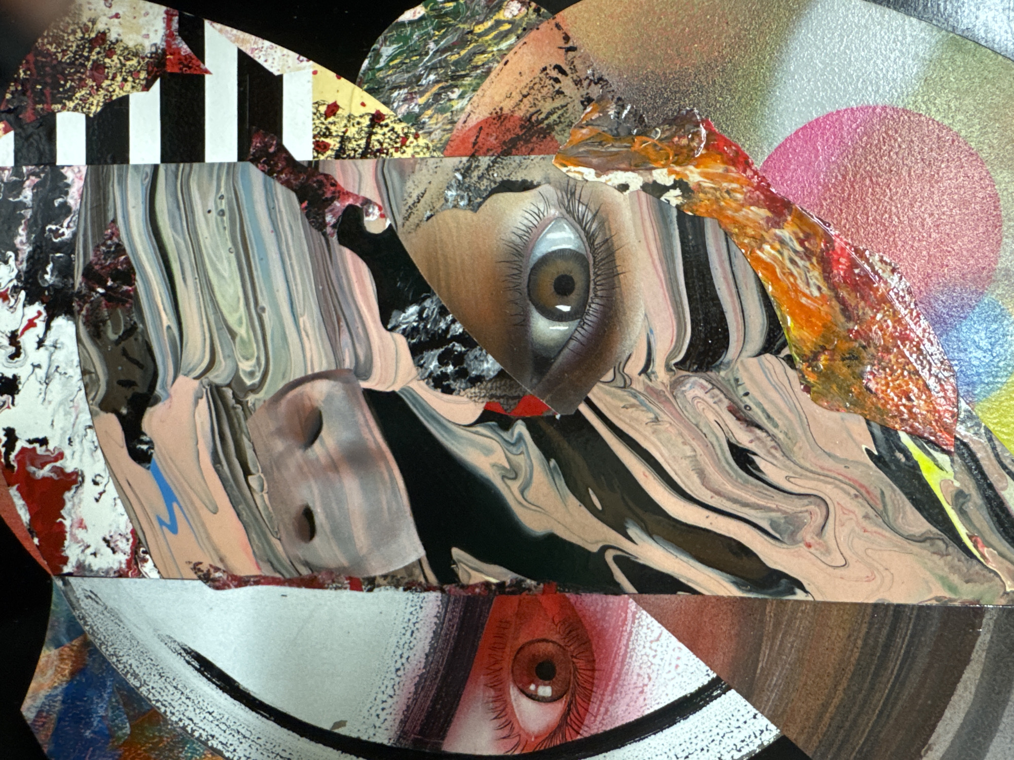 This is a close-up, abstract collage artwork. The artwork features two prominent human eyes, one with a brown iris and the other with a reddish-brown iris. The eyes are surrounded by swirling patterns of paint in various colors including beige, black, white, pink, orange, and yellow. There are also sections of textured paint with red and gold flecks, and black and white stripes. The overall impression is fragmented and surreal, with the different elements overlapping and juxtaposed to create a sense of disarray and intensity. The artwork does not depict any specific location in the city of Clonmel, Ireland, nor does it show any discernible environmental context. It is a purely artistic composition.