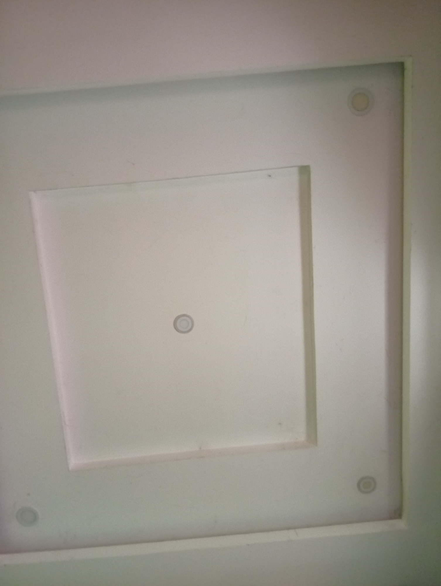 The image shows a white recessed ceiling with a square inset. There are circular ventilation or light fixtures present in the center of the inset and near three of the corners. The scene appears to be indoors, possibly in a room within Aviation Quarters, Nigeria. There are no people or actions visible. The image predominantly features architectural elements.