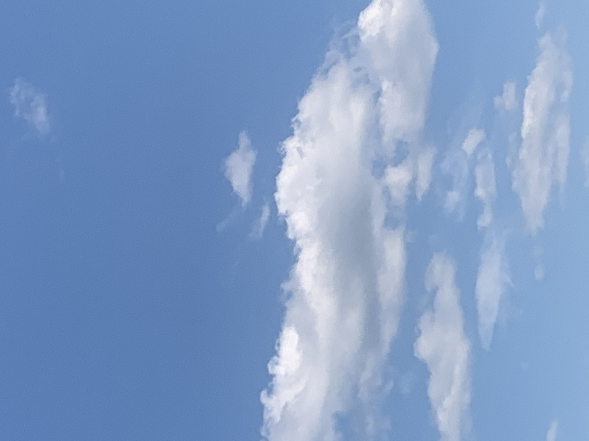 The image depicts a clear blue sky with scattered white cumulus clouds. The clouds vary in size and density, with some appearing wispy and others more substantial. There are no visible structures, people, or other objects in the frame. The scene is entirely focused on the sky and its cloud formations. The location in Kolomyia, Ukraine, cannot be determined from the visual information provided in the image.