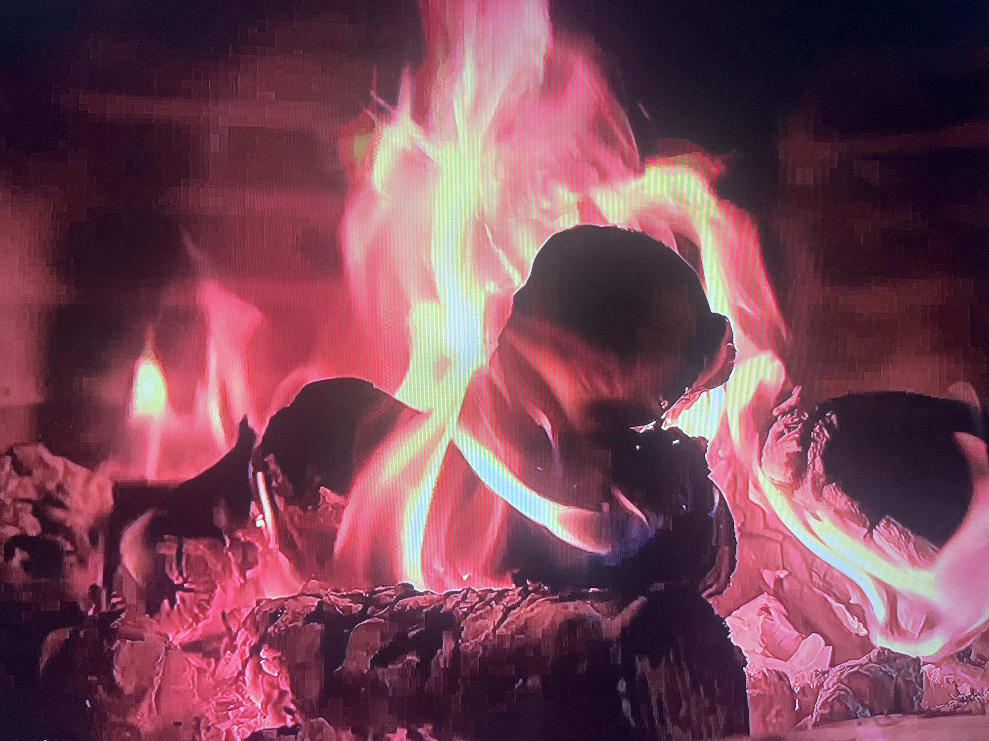 The image depicts a close-up view of a fire burning in a fireplace. The subjects are logs of wood, which are the fuel for the fire, and the flames themselves. The scene is set within a fireplace, indicated by the presence of the burning logs and the glowing embers. The activity taking place is combustion, with the wood actively burning and producing flames.
Notable details include the intense heat and light emanating from the fire, with flames ranging in color from bright yellow and white in the hottest parts to deep reds and oranges at the edges. The logs appear charred and ashy, showing the effects of the fire. The overall impression is one of warmth and intense energy. There are no visible cues to indicate the time of day, weather, or specific emotions, beyond the inherent feelings associated with a fire, such as warmth or coziness. No text is visible in the image. Given the location context of Novocheboksarsk, Russia, this could be a typical scene in a home or other dwelling during colder months.