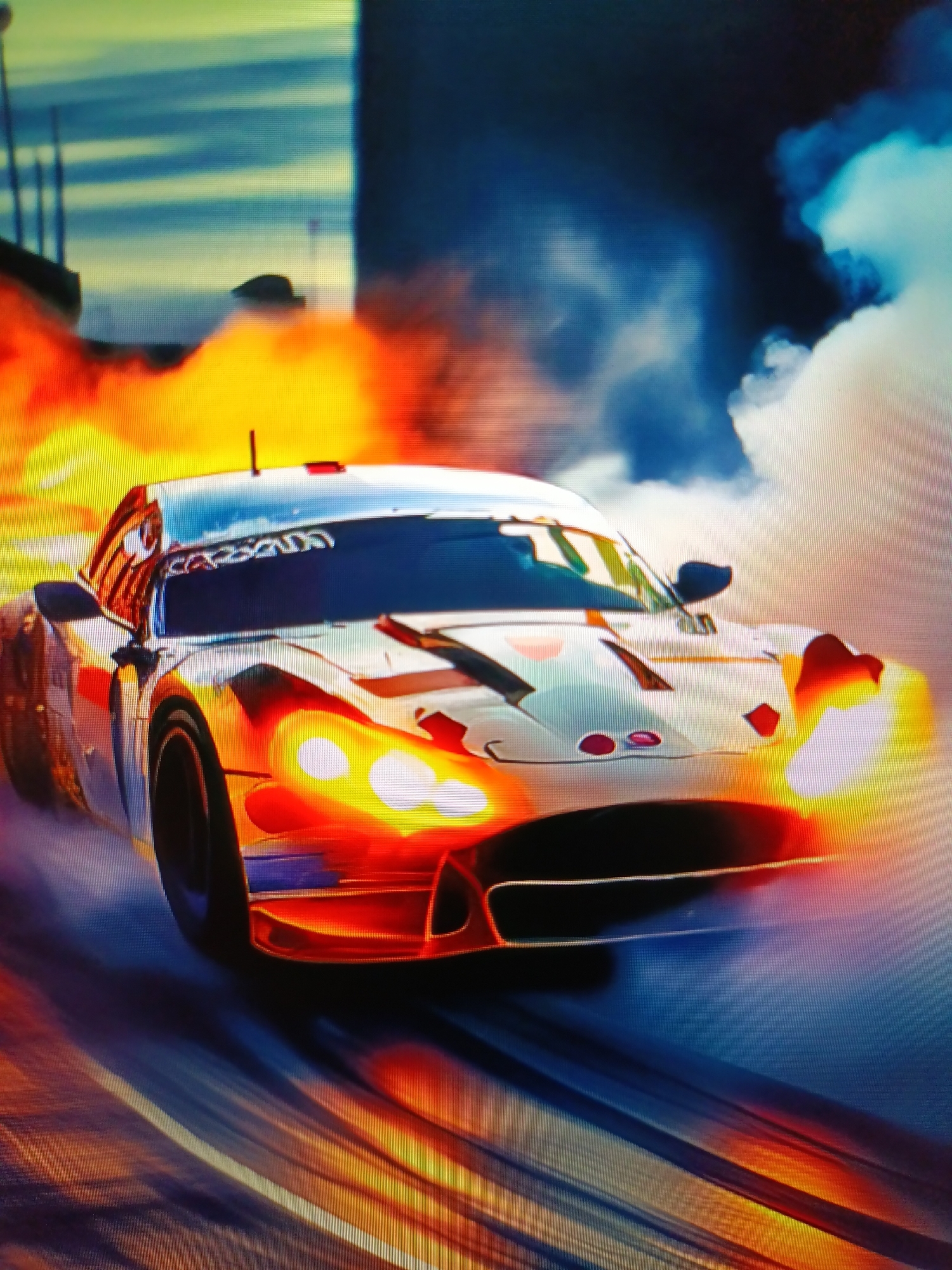An illuminated race car, possibly a sports coupe with a white exterior and orange accents, is depicted in motion, possibly on a racetrack or a city street at night. The car is surrounded by intense orange and yellow flames and billowing white and blue smoke, suggesting a high-speed maneuver or an accident. The car's headlights are brightly lit, and its windshield reflects the dynamic environment. The background is blurred, but suggests a dark, possibly urban setting with hints of structures and a sky with varying shades of blue and yellow. The overall impression is one of dramatic action and speed.