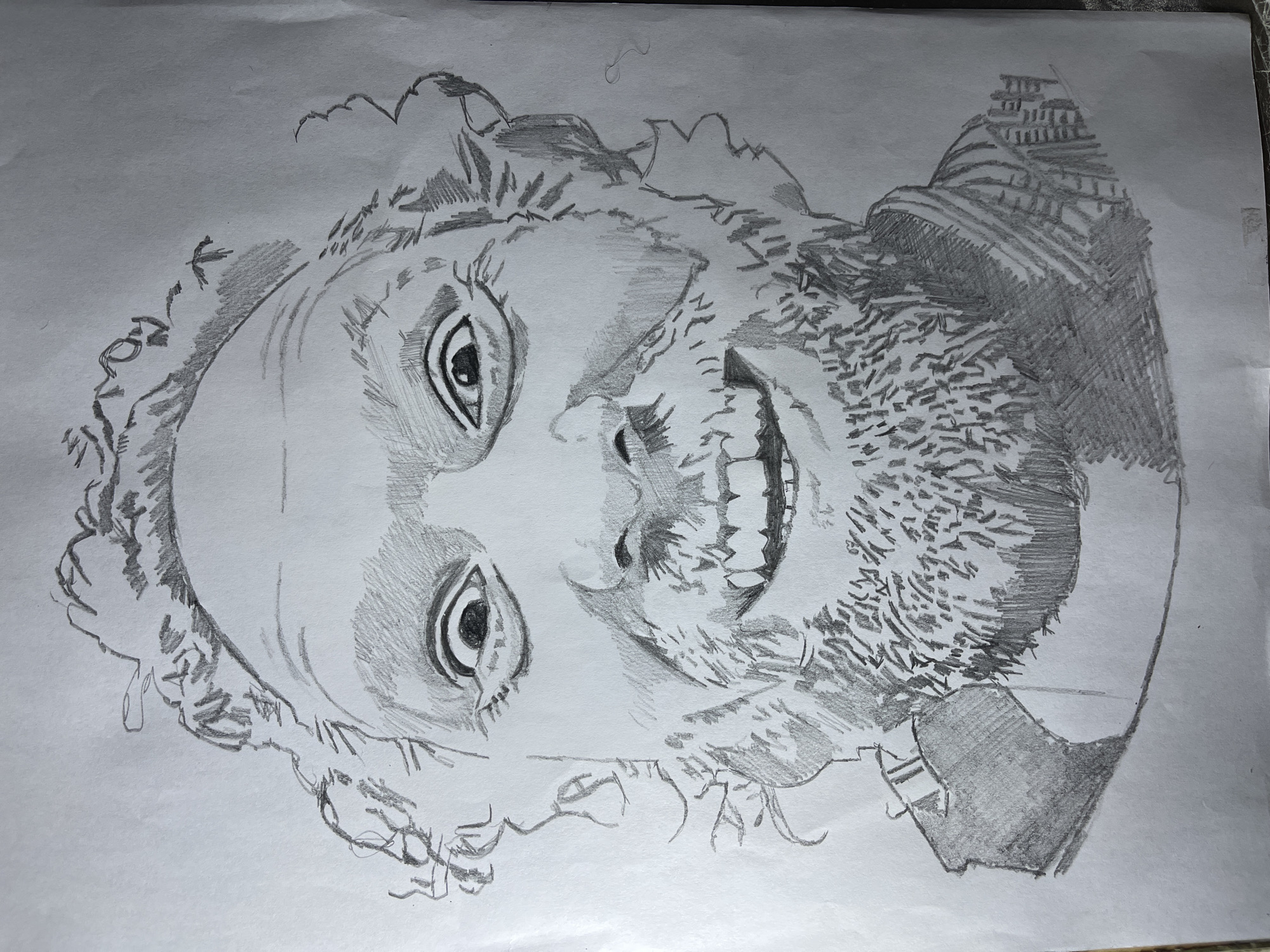 A pencil drawing on white paper depicts a headshot of a man. The man has curly hair and a beard. His mouth is open in a wide smile. The background is plain white paper. There is no indication of location.