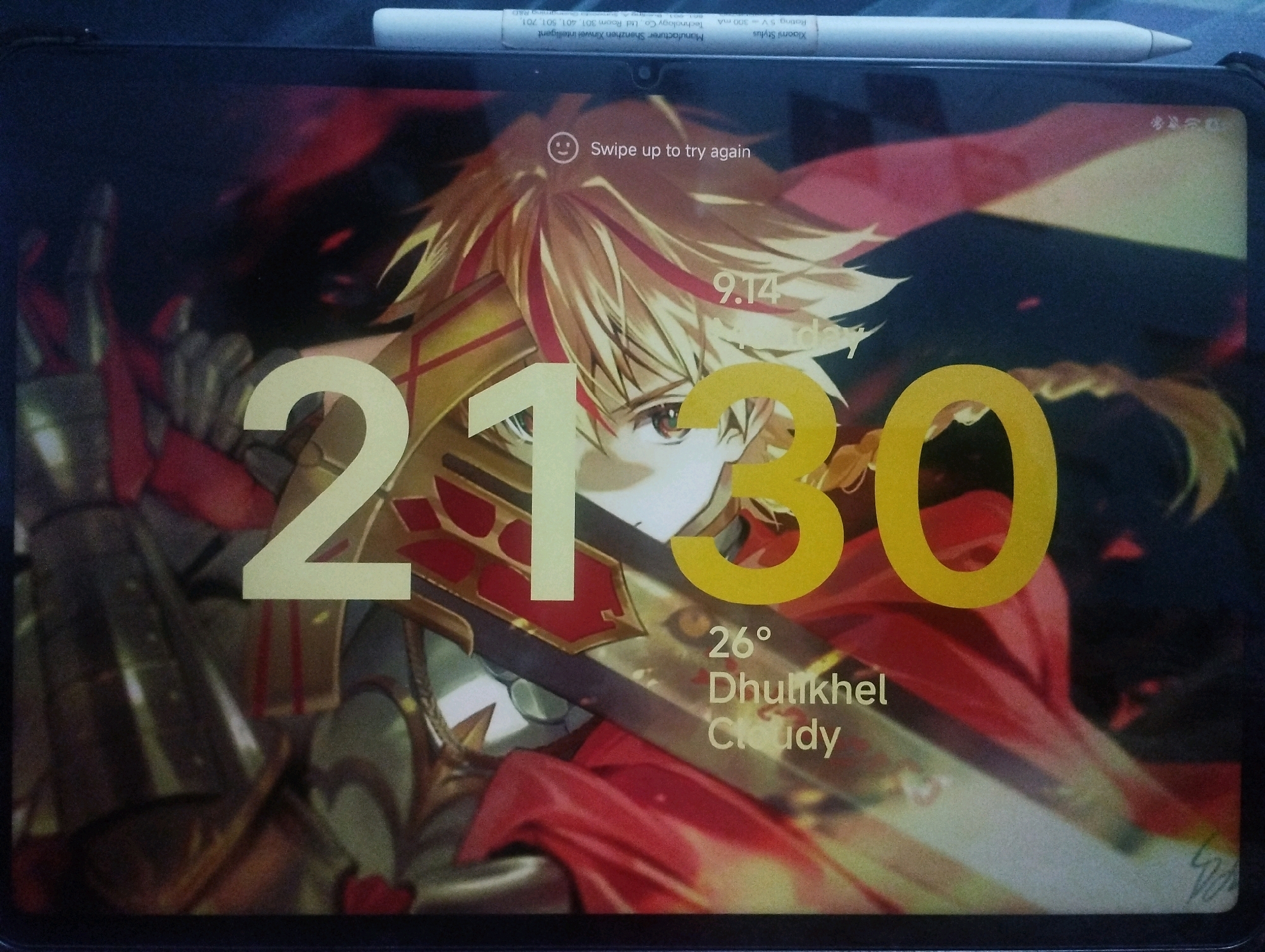 The image is a close-up of a tablet screen displaying a lock screen with an anime-style character. The character has spiky blonde hair with red accents and is wearing golden armor with red fabric. The time displayed on the screen is 21:30. Below the time, the date is 9.14, and the weather is indicated as "26° Dhulikhel Cloudy". The device is placed on a dark surface, and a stylus pen rests horizontally across the top of the screen. The background of the lock screen is dark and abstract with red and black elements.