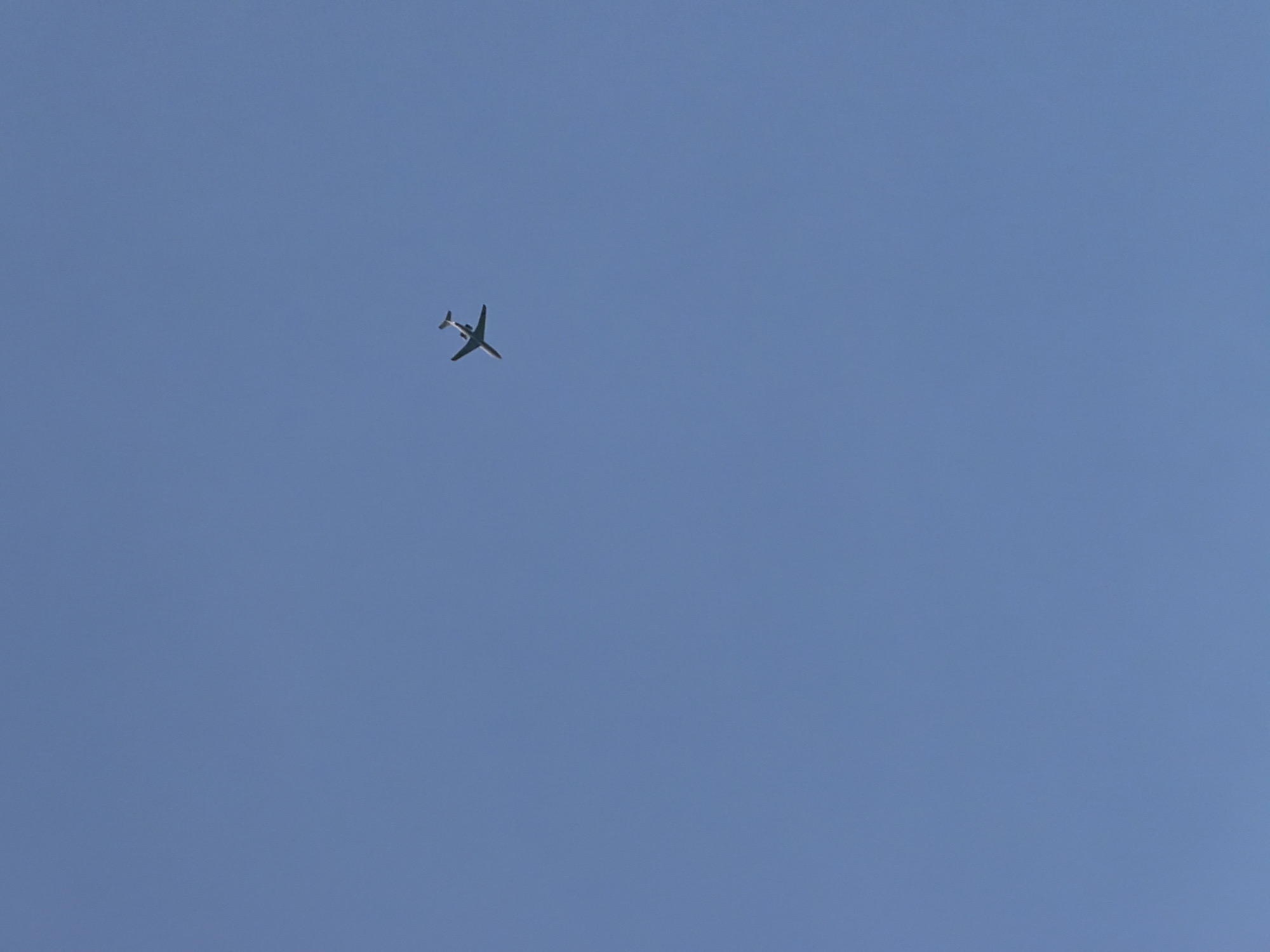 An airplane is flying in a clear blue sky. The image does not provide information about the location in Chaikovsky, Russia.