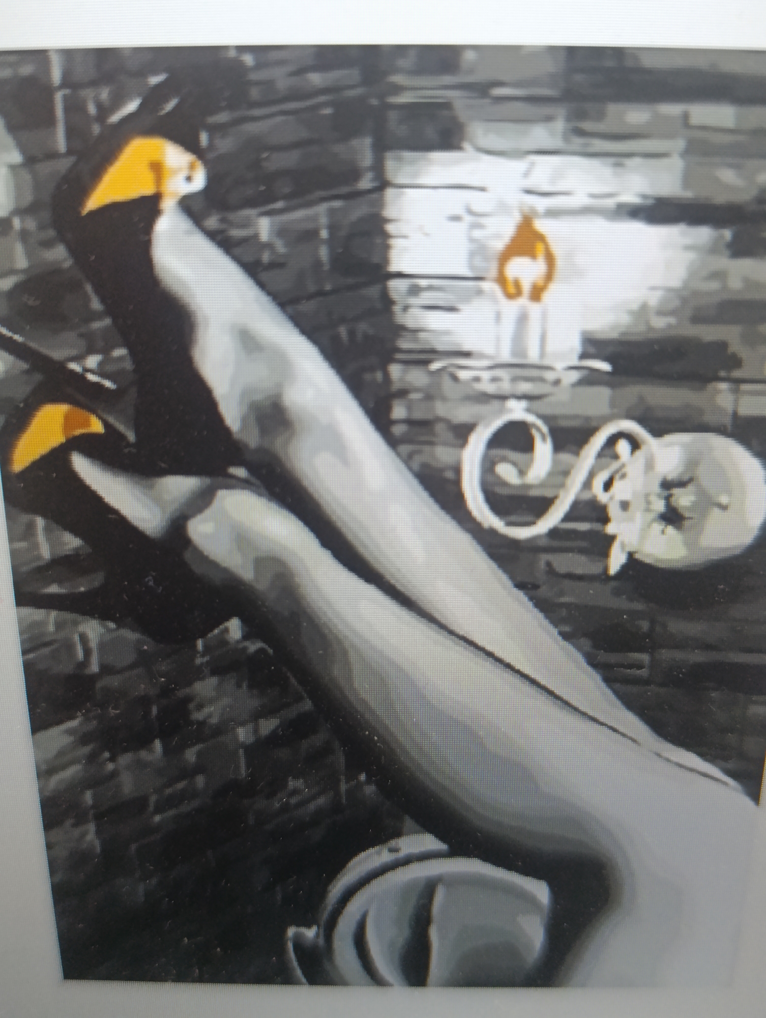 A low-angle, full shot captures two black, high-heeled shoes with yellow accents, resting against a dark, brick-like wall. One shoe is positioned in front of the other, with its toe pointing upwards and out of frame. The second shoe is tucked behind the first, its heel and sole visible. A brass sconce with a candle is mounted on the wall to the right of the shoes, casting a warm glow. The scene is dimly lit, with shadows obscuring much of the background. The overall impression is one of sophistication and mystery.