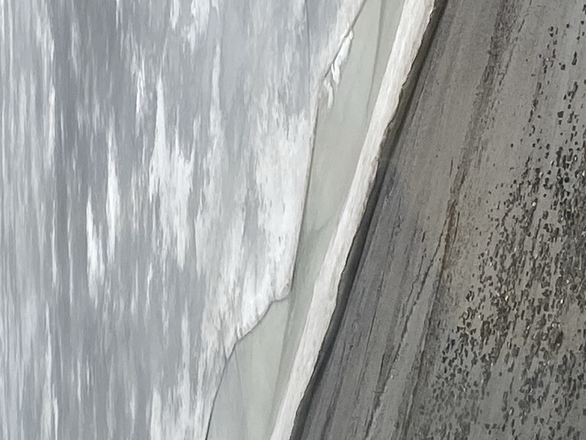 The image shows a close-up view of a textured, likely metallic surface. The surface on the right is rough, with numerous small, reflective spots. To the left of the textured surface is a smooth, reflective material, possibly fabric, which has folds and wrinkles. The lighting is bright, and there are no people or other objects clearly visible in the frame. The image does not provide sufficient information to confirm that it is in Chaikovsky, Russia.