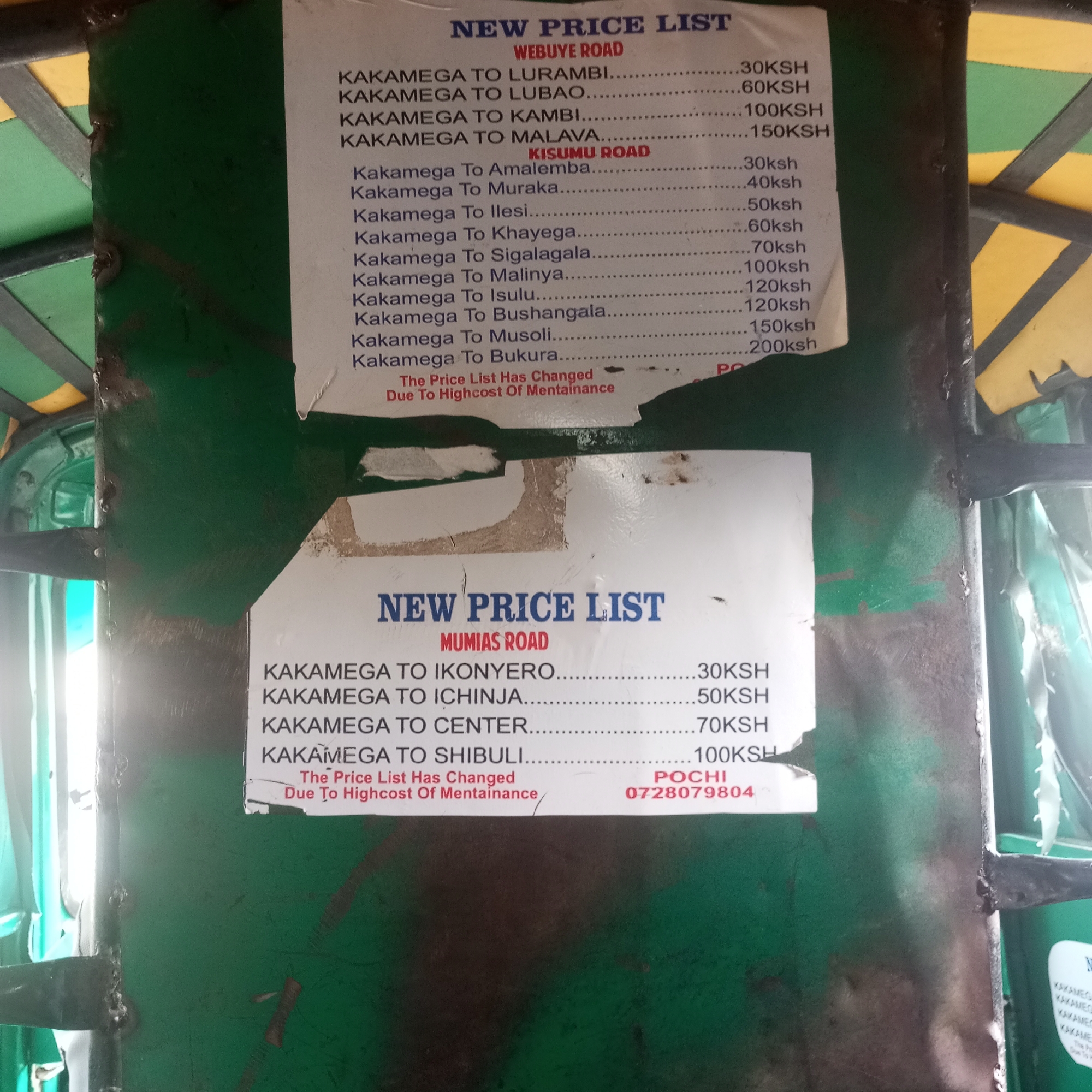 The image shows two price lists posted on a green metal structure, likely a public transportation vehicle like a tuk-tuk. The first list, titled "NEW PRICE LIST - WEBUYE ROAD," lists fares from Kakamega to various destinations like Lurambi, Lubao, Kambi, and Malava. A second section, labeled "KISUMU ROAD" shows prices from Kakamega to Amalemba, Muraka, Ilesi, Khayega, Sigalagala, Malinya, Isulu, Bushangala, Musoli, and Bukura. The second price list, titled "NEW PRICE LIST - MUMIAS ROAD," lists fares from Kakamega to Ikonyero, Ichinja, Center, and Shibuli. Both lists indicate that the price changes are "Due To Highcost Of Mentainance." A phone number, 0728079804, and the name "POCHI" are printed at the bottom of the second list.