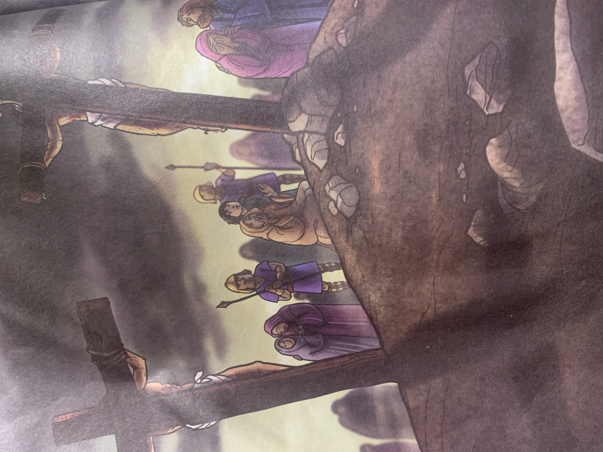 The image depicts a somber scene, likely a religious illustration, showing a crucifixion event. In the foreground, a large wooden cross is visible on the left, with the lower part obscured by shadow. Further to the right and slightly behind, another cross stands prominently, displaying a crucified figure. Around the base of the crosses, a group of people are gathered. Two individuals in purple robes are embracing each other, their faces conveying distress. A figure in a purple tunic and helmet stands with a spear, appearing to be a guard. To the right, a person in a pink robe is seen crying with their face buried in their hands, comforted by another figure in blue. Other figures in muted colors are present in the background, some shrouded and indistinct. The environment is a rocky, uneven terrain under a dark, cloudy sky, suggesting a dramatic or somber atmosphere. There is no indication or visual information within the image to suggest any connection to Jauro Yinu, Nigeria.