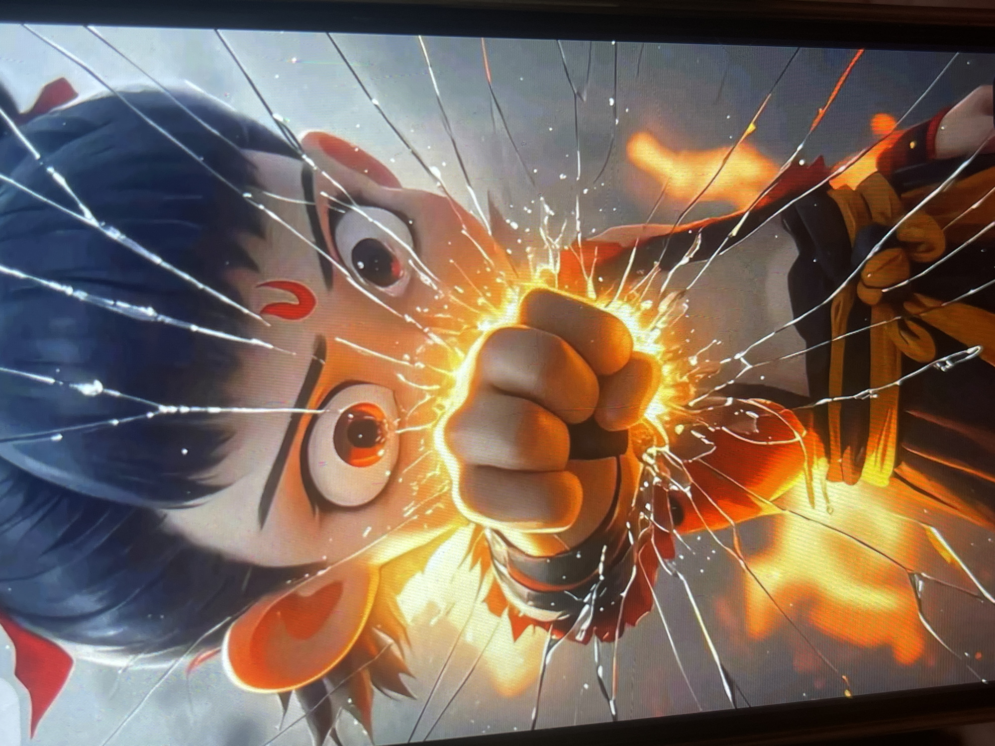 The image shows a close-up of an animated character's face, with a fist striking the screen from the front, creating a cracked glass effect. The character has dark hair tied up with a red ribbon, large orange eyes, and a red crescent mark on its forehead. It's wearing a dark outfit with orange and yellow accents. Sparks and fire are visible around the fist and the character's face, suggesting an action scene. The background is blurred and appears to be a gray, indistinct environment with some orange glows. The image does not contain any information that would allow for the identification of a location in Bishkek City, Kyrgyzstan.