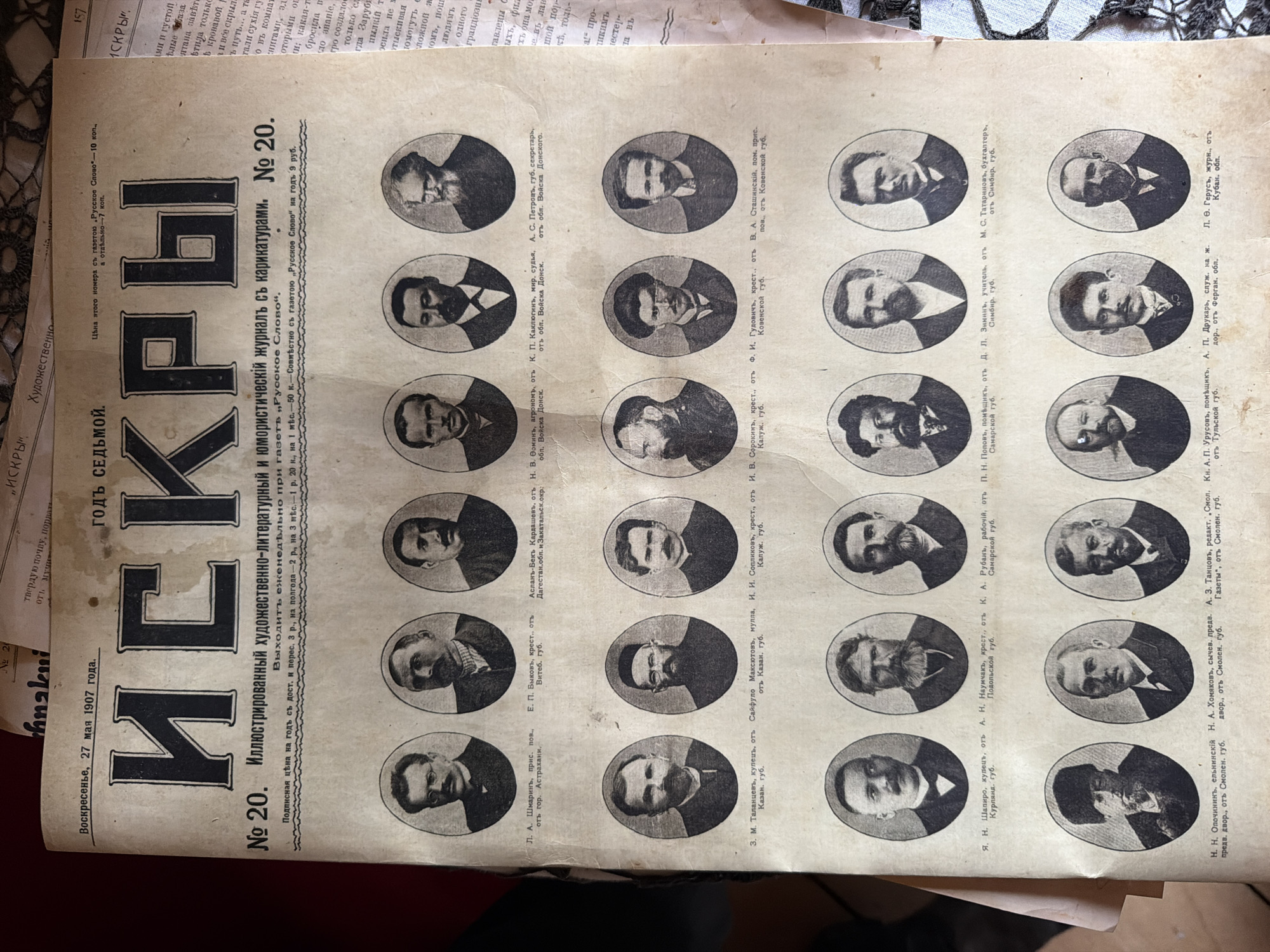 The image is a scan of the front page of a Russian newspaper titled "ИСКРЫ" (Iskry), dated "Воскресенье, 27 мая 1907 года" (Sunday, May 27, 1907). The newspaper is a weekly illustrated literary and humorous journal with caricatures, published as issue number 20.
The page is dominated by a large title "ИСКРЫ" in bold, stylized font. Below the title, there is a description of the publication, including its price and subscription details. The majority of the page is filled with a grid of oval portraits of men, arranged in rows and columns. Each portrait is accompanied by a caption identifying the person, their profession, and their place of origin, typically a guberniya (province) in Russia.
The men depicted are presented in formal attire, suggesting they are notable figures. The captions indicate a variety of professions, including landowner, merchant, peasant, doctor, military official, and various other professions. The locations mentioned in the captions are spread across different regions of the Russian Empire, such as Astrakhan, Samara, Kazan, Kaluga, Tula, Simbirsk, and others.
There is no depiction of the city of Ust'-Kabyrza, Russia, within this image. The image is solely of a printed newspaper page.