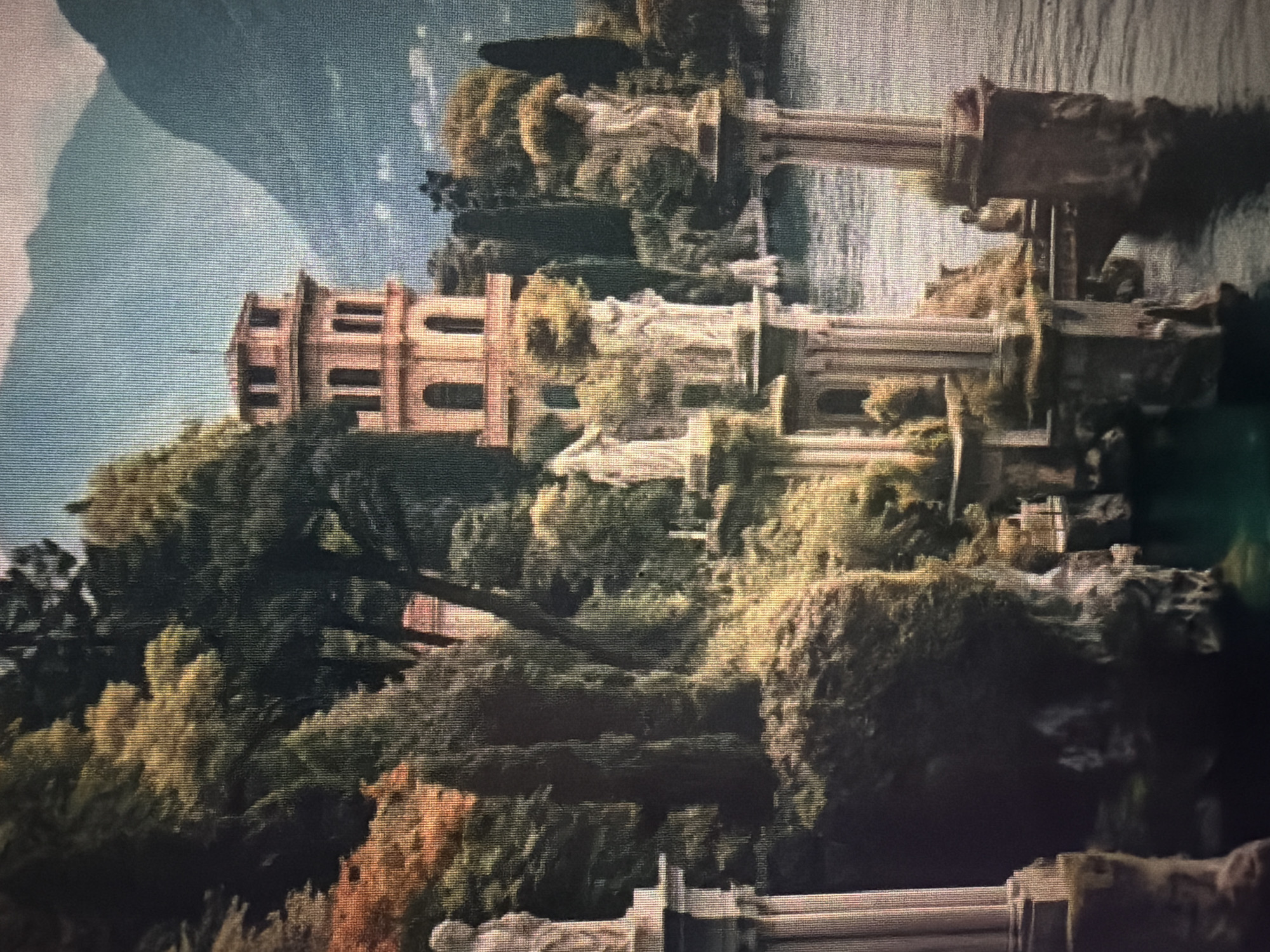 The image depicts a grand, classical architectural complex situated on a cliff overlooking a body of water, likely a lake or bay. The architecture is characterized by classical columns, arches, and statues, suggesting a European or Mediterranean influence. A prominent, multi-story tower with arched windows dominates the upper portion of the scene. Lush, dense foliage, including trees and shrubs, surrounds the structures, with autumnal colors visible in some areas. In the background, imposing mountains rise, their slopes shrouded in mist. The water is calm, reflecting the surrounding landscape. The scene is serene and somewhat melancholic, evoking a sense of history and grandeur. This image is not located in Baan Mae Nam, Thailand, as the architecture and landscape are inconsistent with that region.