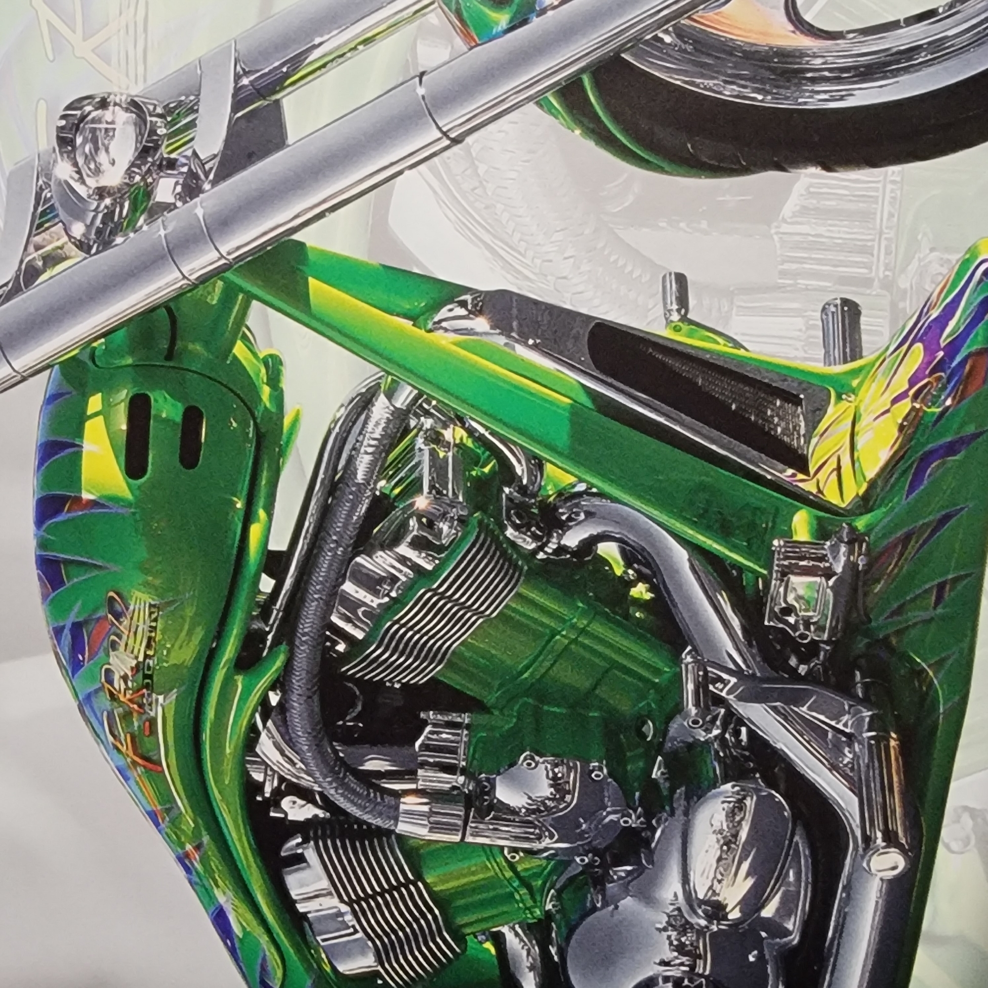 This is a close-up, high-angle, medium shot of a highly customized green motorcycle. The motorcycle is adorned with intricate airbrushed designs featuring green, yellow, blue, and red colors, possibly depicting flames or tribal patterns. The chrome details of the engine, exhaust pipes, and handlebars are highly polished and reflect the light.
The image focuses on the central engine area and part of the frame. The engine appears to be a V-twin, with prominent fins on the cylinders and polished covers. Several chrome pipes, likely exhaust and intake manifolds, are visible, along with black braided hoses. The frame itself is painted a vibrant green.
In the upper left corner, a portion of a chrome handlebar and a headlight assembly are visible. The headlight has a clear lens with reflective elements inside. Towards the top right, a portion of the motorcycle's rear tire and rim is visible, also with chrome accents.
The background is softly focused and appears to be a pale, neutral color, possibly a wall or a studio backdrop, with faint outlines of what could be other motorcycles or automotive parts. There is no indication of the time of day, weather, or a specific outdoor location. The image is detailed and suggests a focus on the craftsmanship and aesthetic of the motorcycle. No discernible text is visible in the image.