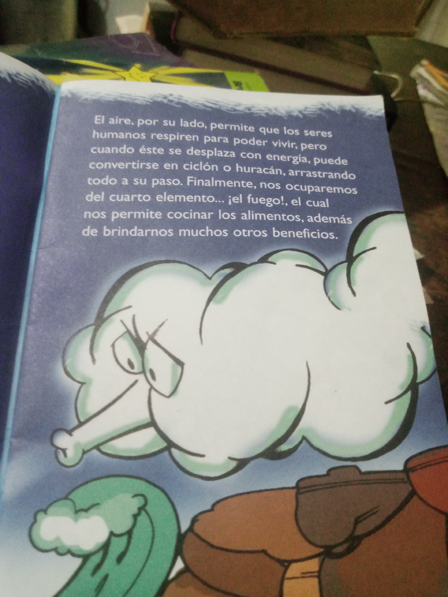 The image shows a page from a book with text and an illustration. The text is in Spanish and describes the properties and uses of air, mentioning its ability to sustain life, its power to become a hurricane, and its role in cooking. The illustration depicts a personified cloud with a stern expression, blowing air from its nose. Below the cloud, a green wave with white foam is visible, suggesting a coastal or maritime theme. The overall scene is part of a narrative explaining natural elements. The image does not contain any information about the city of Santa Ana, Venezuela.