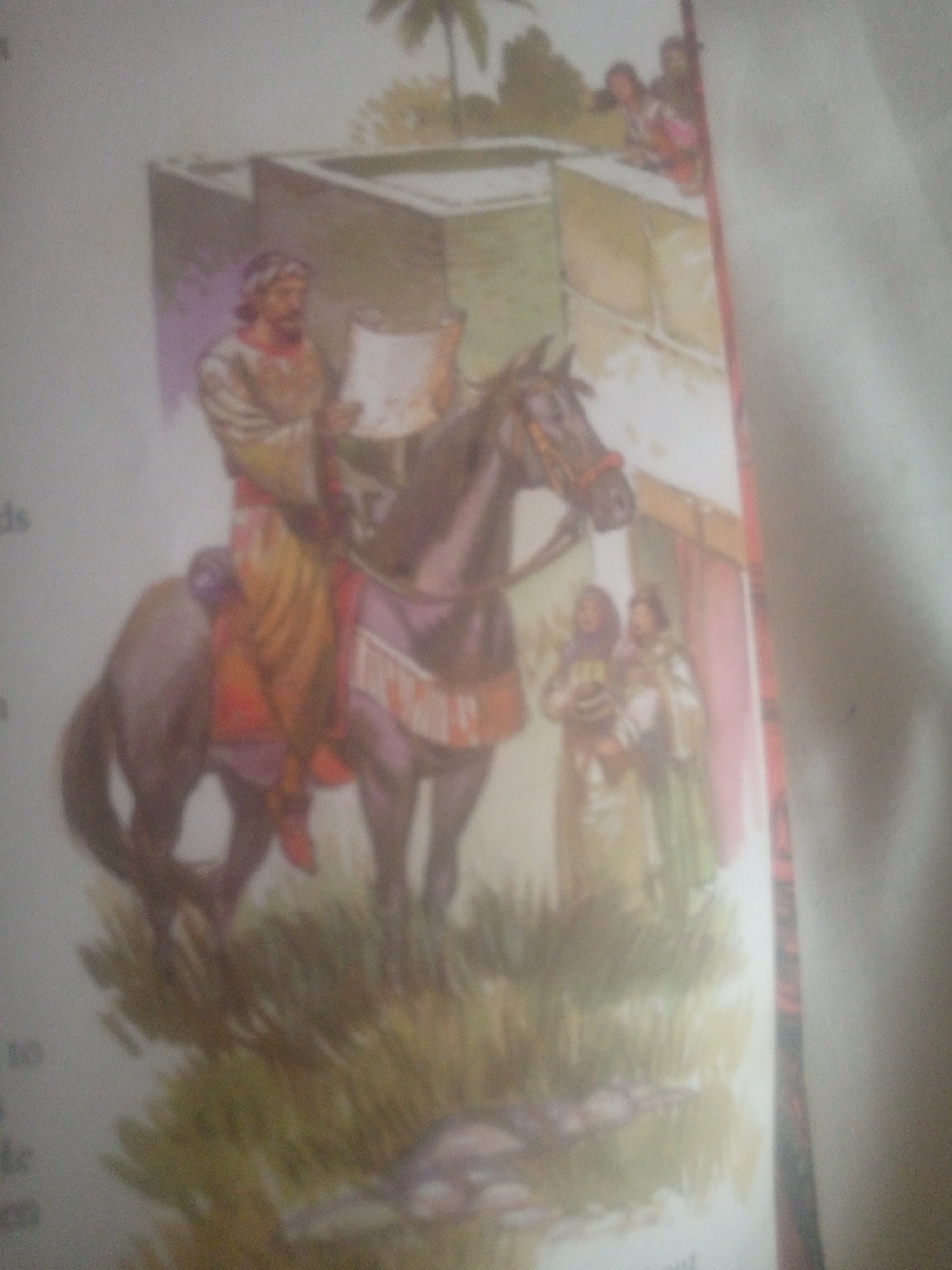 The image depicts an illustration of a man on horseback holding a scroll. He is wearing traditional clothing with a turban. Beside the horse, two women are standing, one of whom appears to be holding a child. In the background, there is a building with a flat roof and some vegetation, including a palm tree. The scene is set in what appears to be an outdoor, possibly historical or biblical setting. There is no information or visual cue within the image that would suggest a specific location in the city of Jauro Yinu, Nigeria.
