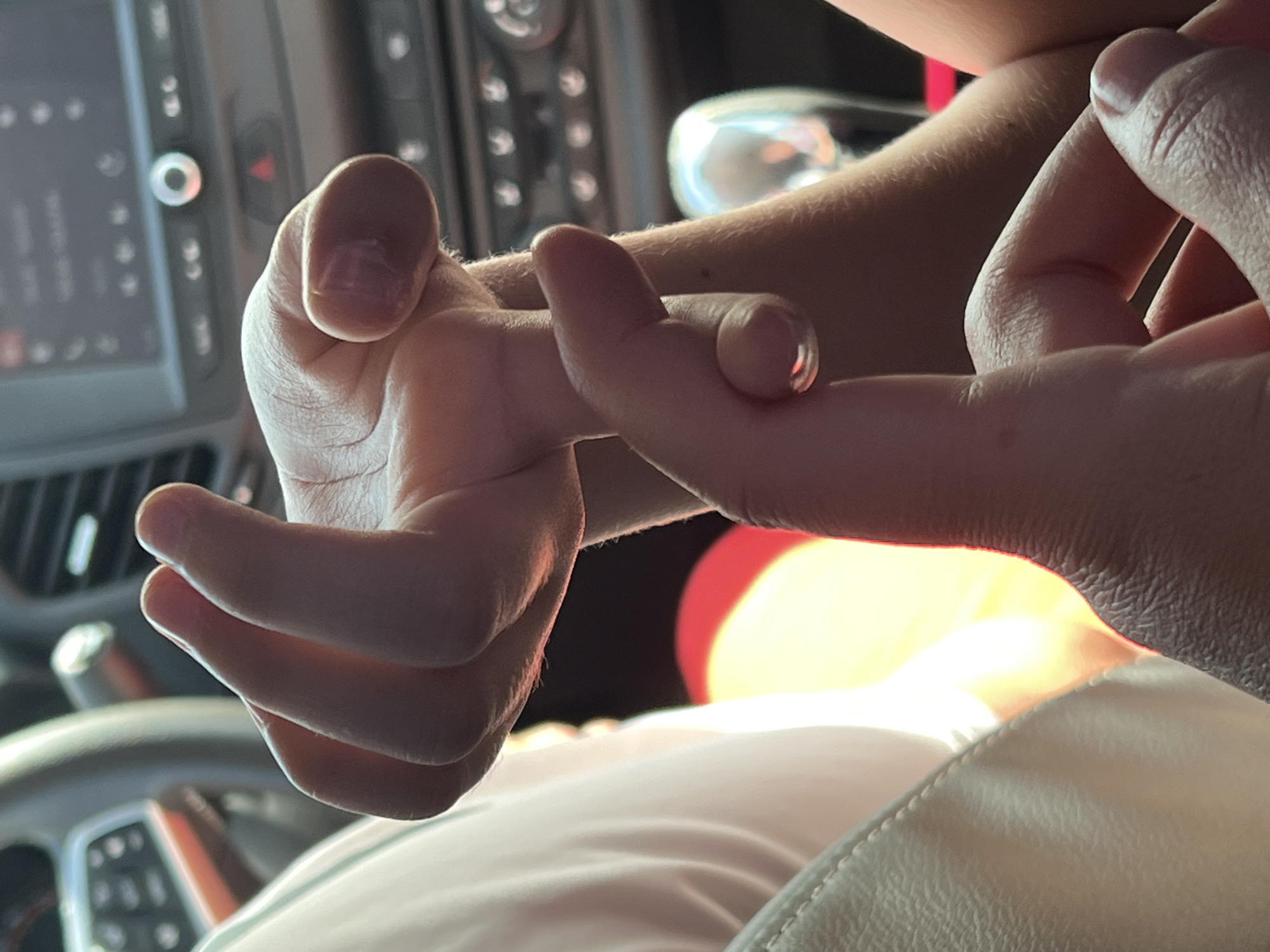 A close-up shot inside a car focuses on a person's hands intertwined. The steering wheel and dashboard are partially visible in the background. The specific location in Niva, Russia cannot be determined from this image.