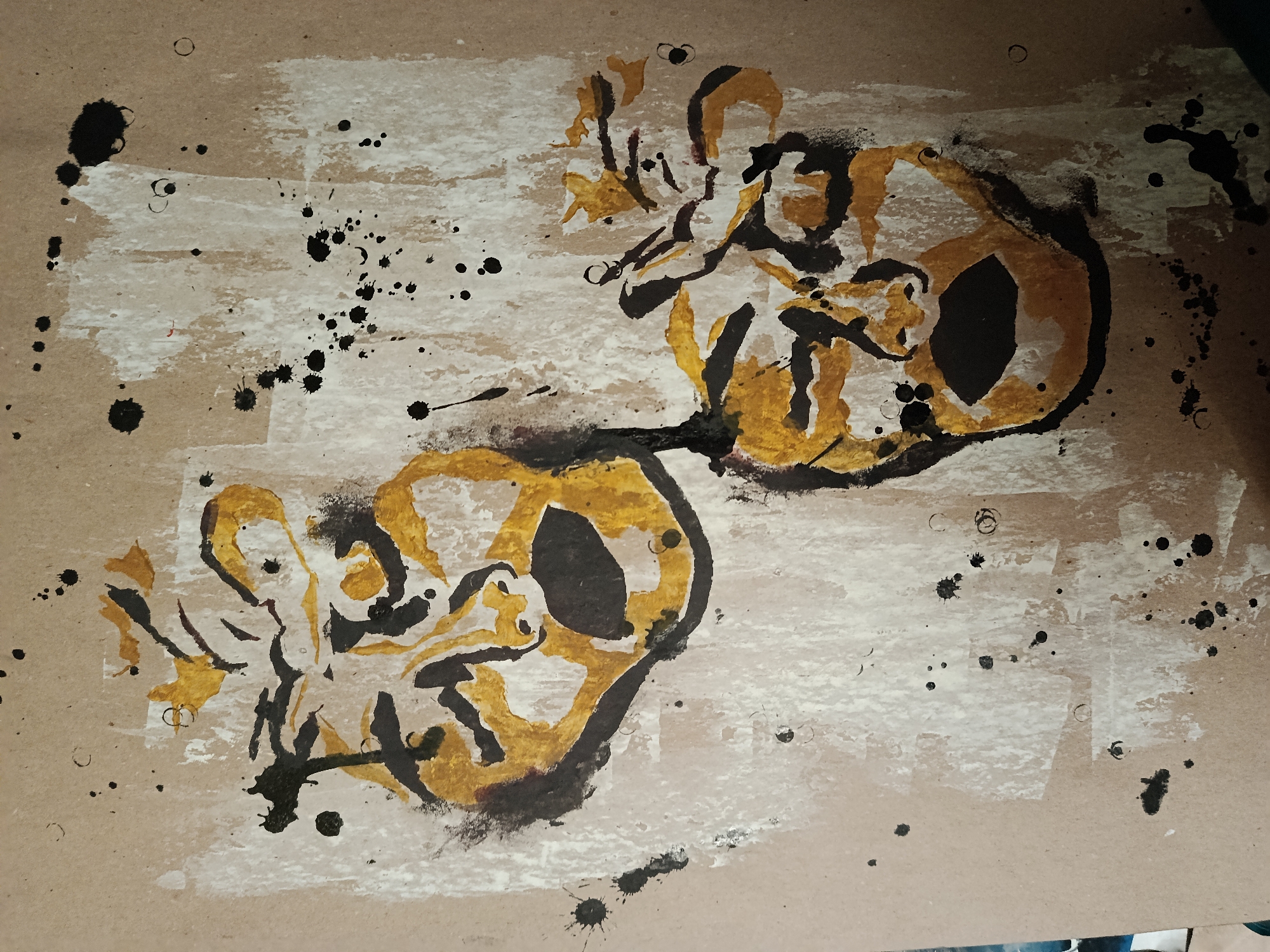 The image is an abstract painting on a beige surface, possibly paper or cardboard. It contains two primary, somewhat circular forms connected by a thin line. These forms are outlined in black and filled with shades of yellow and gold. Black splatters are scattered across the background and within the shapes. Broad strokes of white paint are also visible, adding texture to the background. The artwork does not depict any location in Moscow, Russia. There are no people, subjects, or objects that would indicate a specific location in Russia. It is purely an abstract composition.