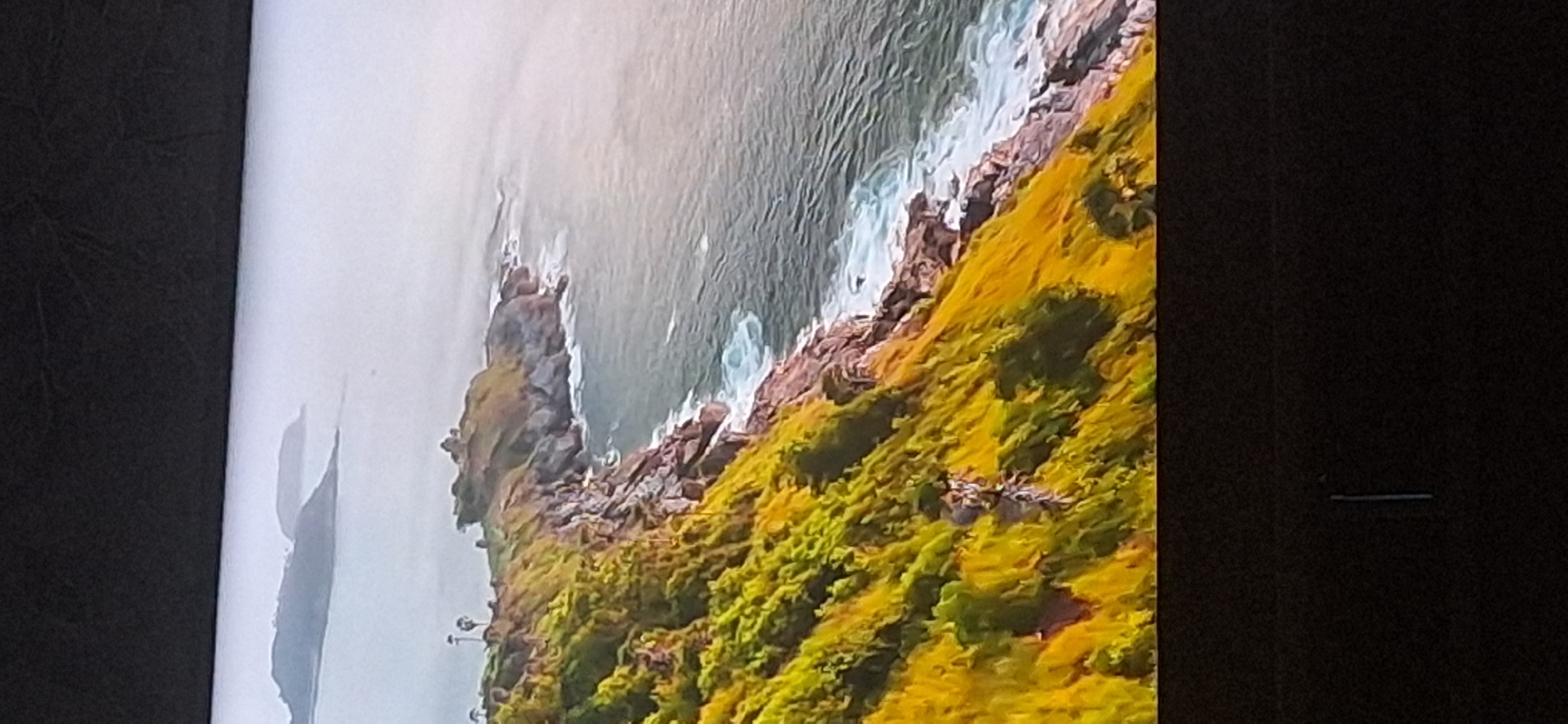 The image shows a dramatic coastal landscape with rugged cliffs covered in lush green and yellow vegetation. The sea below is a deep blue-green, with white waves crashing against the rocky shore. In the distance, faint outlines of islands can be seen through a hazy atmosphere. The scene appears to be a natural, undeveloped area. There is no indication of the city of Bila Tserkva, Ukraine, or any urban elements within the image.
