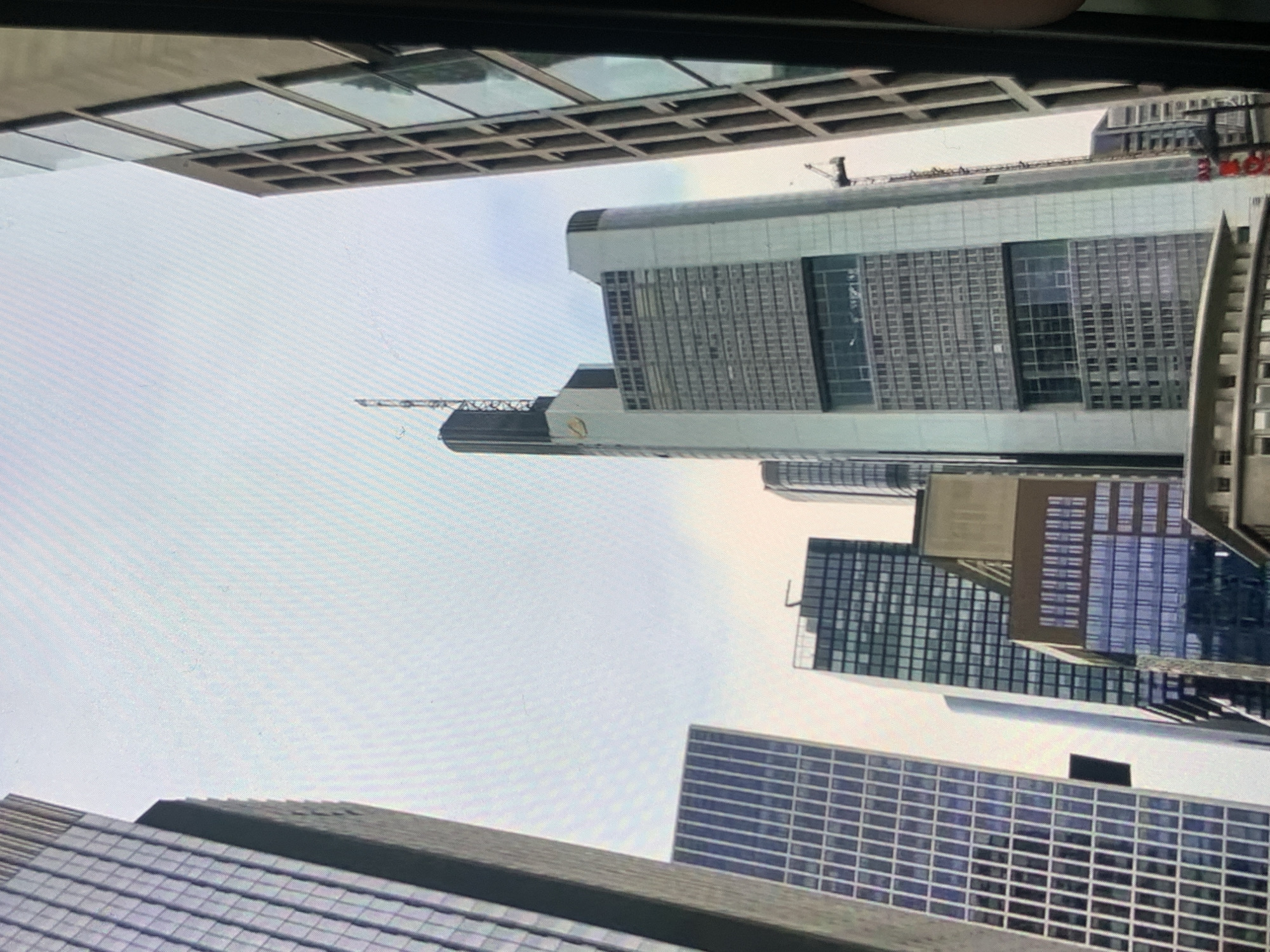 The image shows a cluster of modern skyscrapers in a city. The buildings are tall and made of glass and concrete, with various architectural styles. The sky is overcast. The perspective is looking upwards, emphasizing the height of the structures. No people are visible in the image. The provided crops highlight different sections of the buildings, showing details of their facades and the surrounding environment. The location is identified as Stavropol, Russia.