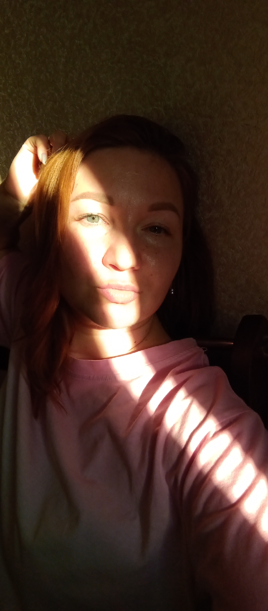 A woman with auburn hair, wearing a pink shirt, is in a room. Light streaks across her face and body. The location is Unknown, Unknown.