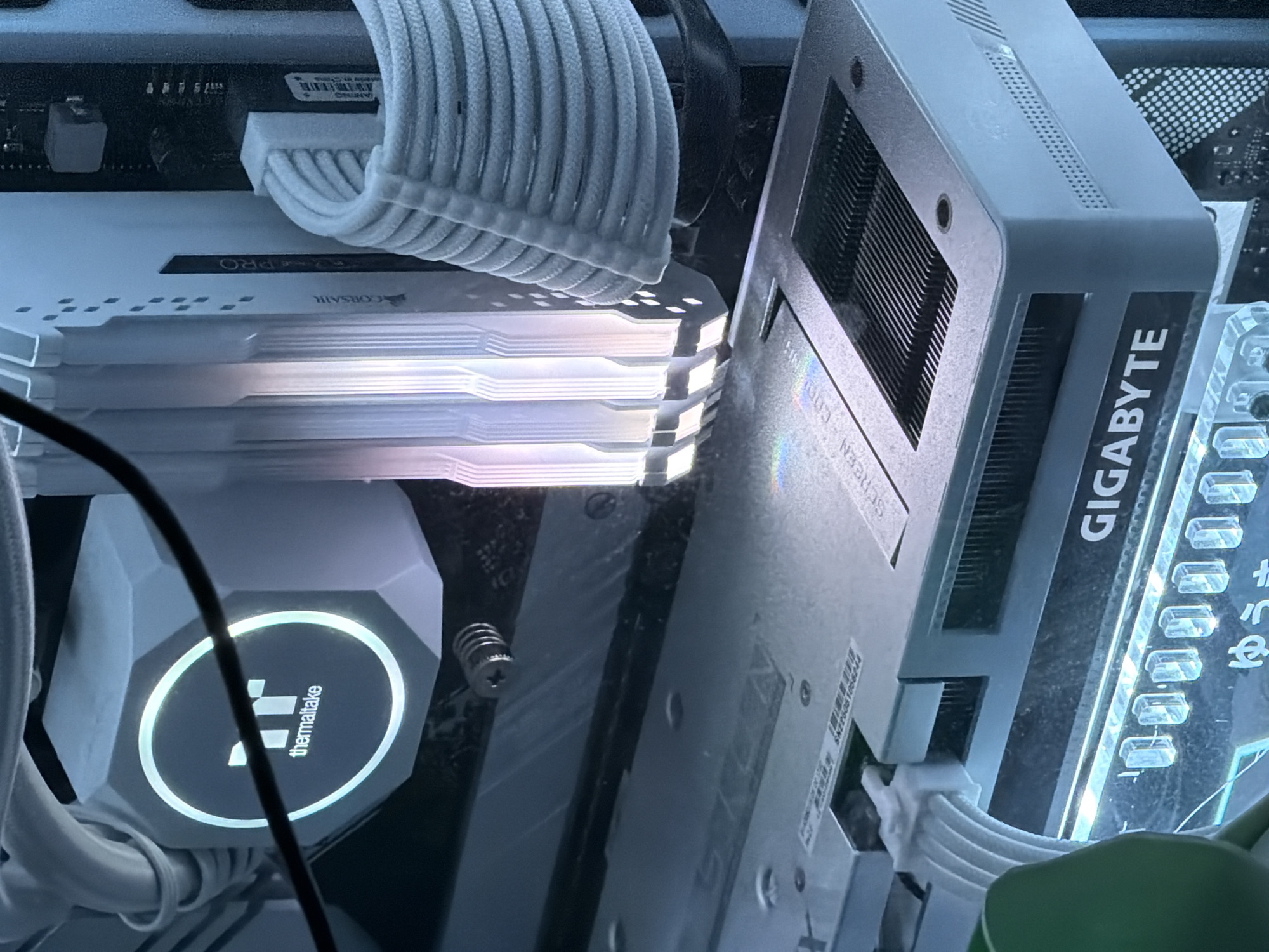 The image shows a close-up view of the interior of a computer, likely a desktop PC. Key components visible include a CPU cooler with a "thermaltake" logo, RAM modules with "CORSAIR" branding, a graphics card with "GIGABYTE" branding, and various white cables. The components are illuminated by internal lighting, creating a colorful and vibrant effect. There are no people present in the image, and no geographical indicators suggest a specific location in Khimki, Russia. The scene is a static arrangement of computer hardware.