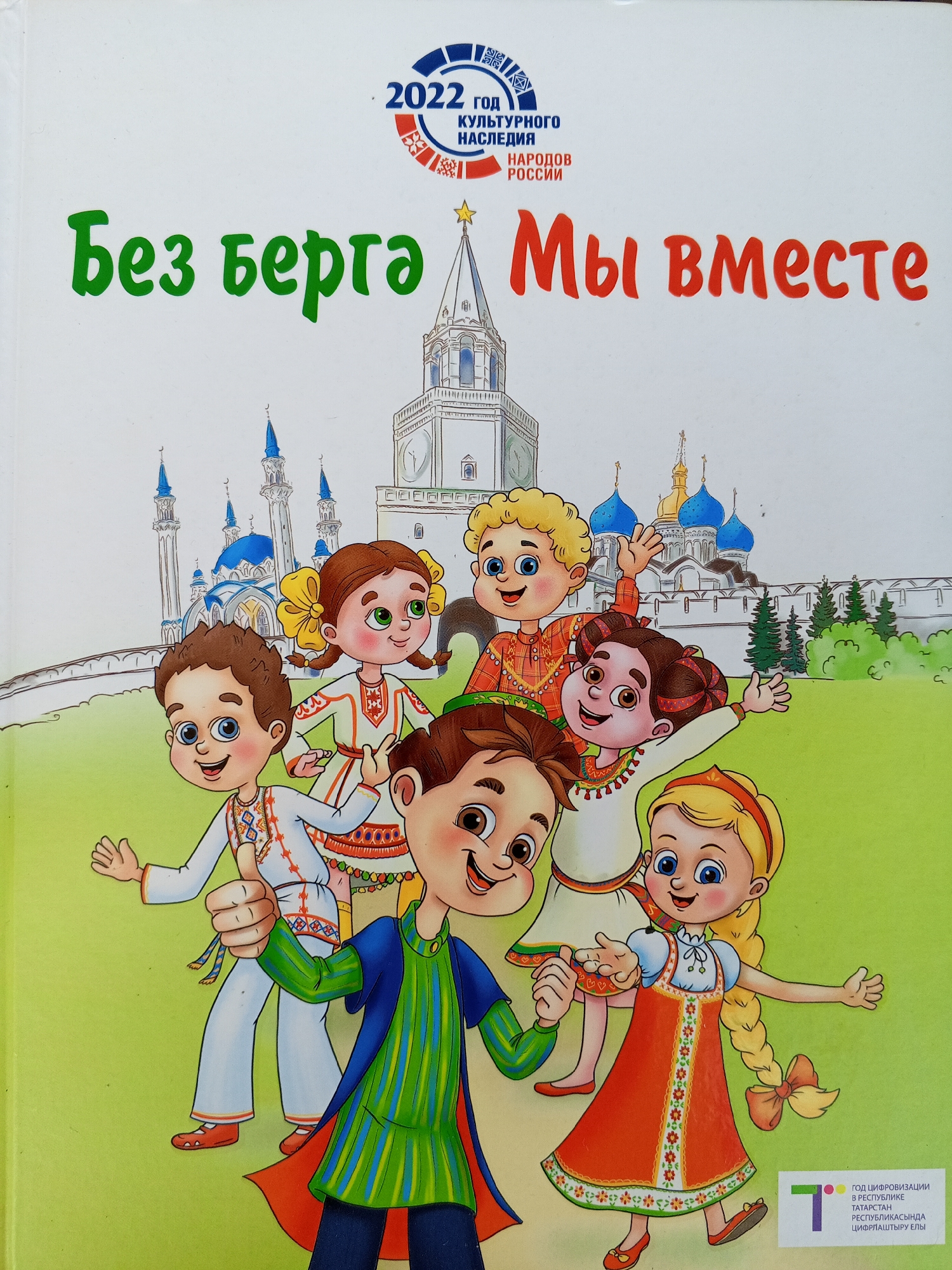 The image is the cover of a book titled "Без бeрга Мы вместе" which translates to "Without borders, we are together." The title is prominently displayed in large green and red letters against a white background. At the top of the cover, a circular emblem for "2022 год культурного наследия народов России" (2022 Year of Cultural Heritage of the Peoples of Russia) is visible.
The lower portion of the cover features a colorful illustration of five cartoon children in traditional Russian attire, standing in front of a stylized depiction of Kazan Kremlin. The children are diverse in appearance, with varying hair colors and skin tones, and they are all smiling and waving. The Kazan Kremlin is depicted with its characteristic white walls, blue-domed mosques, and tall minarets, along with a golden star atop one of the spires. The background is a light green, representing a grassy field.
The image does not depict the city of Chistopol, Russia, but rather a stylized representation of the Kazan Kremlin, which is the capital of Tatarstan and a UNESCO World Heritage site. There is no indication of Chistopol in the image.