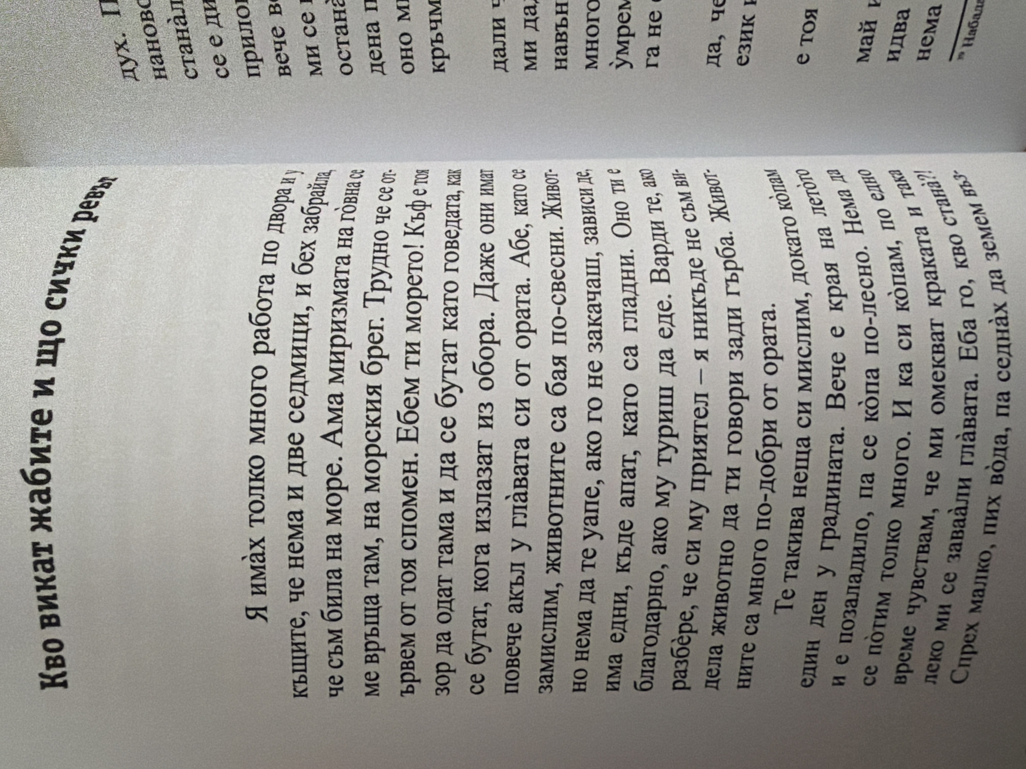 This is a close-up photograph of an open book. The pages display Bulgarian text printed in black. The left page has a title in larger, bolded font that reads "Kvo vikat zhabite i, sto sichki revyat" (Who the frogs call and why all shout). Below the title, smaller text continues in multiple paragraphs. The right page also contains columns of smaller black text. The book appears to be on a flat surface, likely a table, and the lighting suggests it is indoors. There are no visual elements in the image that indicate a specific location within the city of Pazardzhik, Bulgaria.