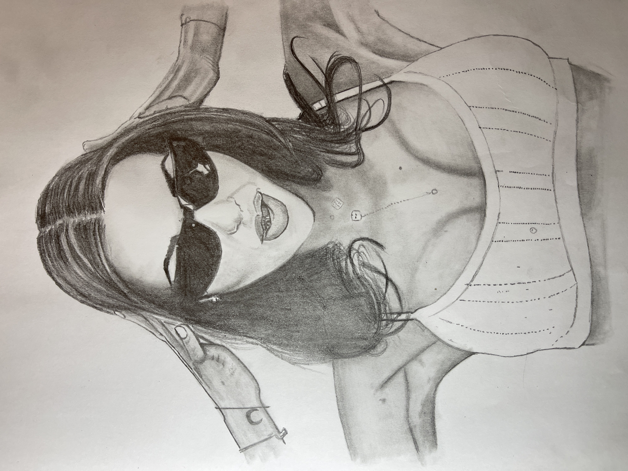 A charcoal drawing depicts a woman with sunglasses, lying on her side. She wears a light-colored, striped top. A necklace with small pendants adorns her neck, and a bracelet is on her wrist. One hand is near her head, while the other is visible near her torso. The scene does not explicitly depict any location in Jos, Nigeria, or any interaction with the environment.