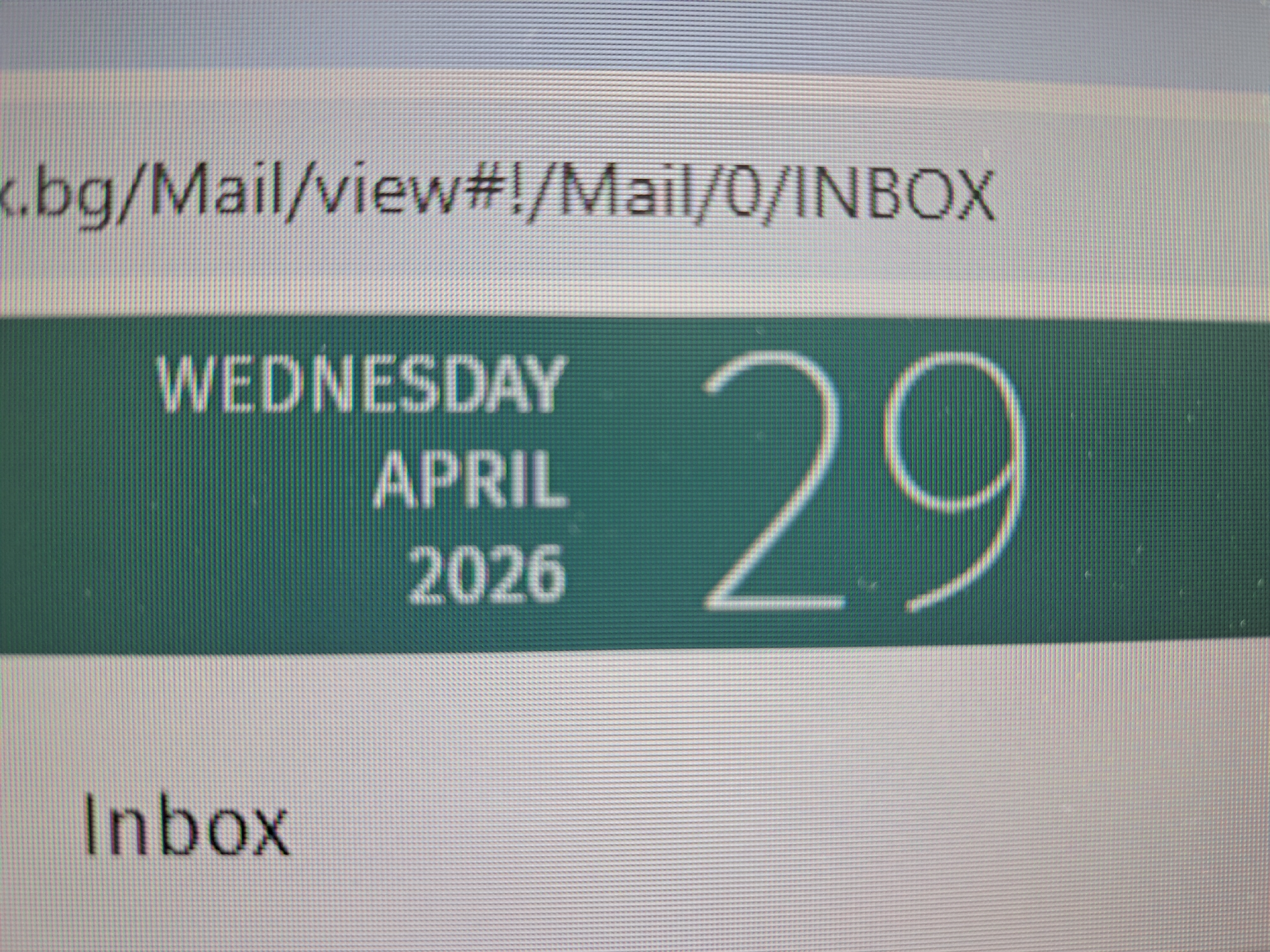 This is a close-up image of a computer screen displaying an email interface. The browser URL is visible at the top, partially obscured, reading ".bg/Mail/view#!/Mail/0/INBOX". The main focus is a green bar showing the date "WEDNESDAY APRIL 29 2026" in white text. Below this bar, the word "Inbox" is visible. The screen resolution and pixel grid are apparent. The location of the scene is a digital environment, specifically within a web browser, not a physical city.