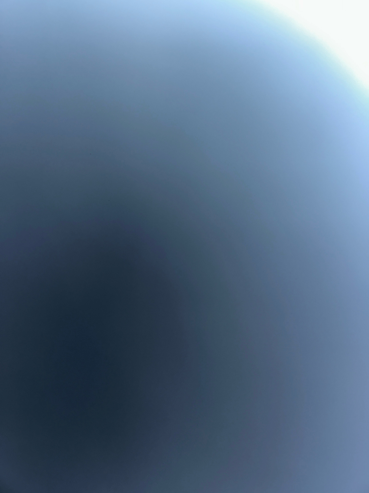 The image is an out-of-focus, abstract shot that appears to be of the sky or a hazy atmosphere. The colors are predominantly blues and grays, with a bright, washed-out area in the upper right corner. There are no discernible objects, people, or specific landmarks visible. Without any context or distinct features, it is impossible to determine its location, including whether it is in Baku, Azerbaijan.