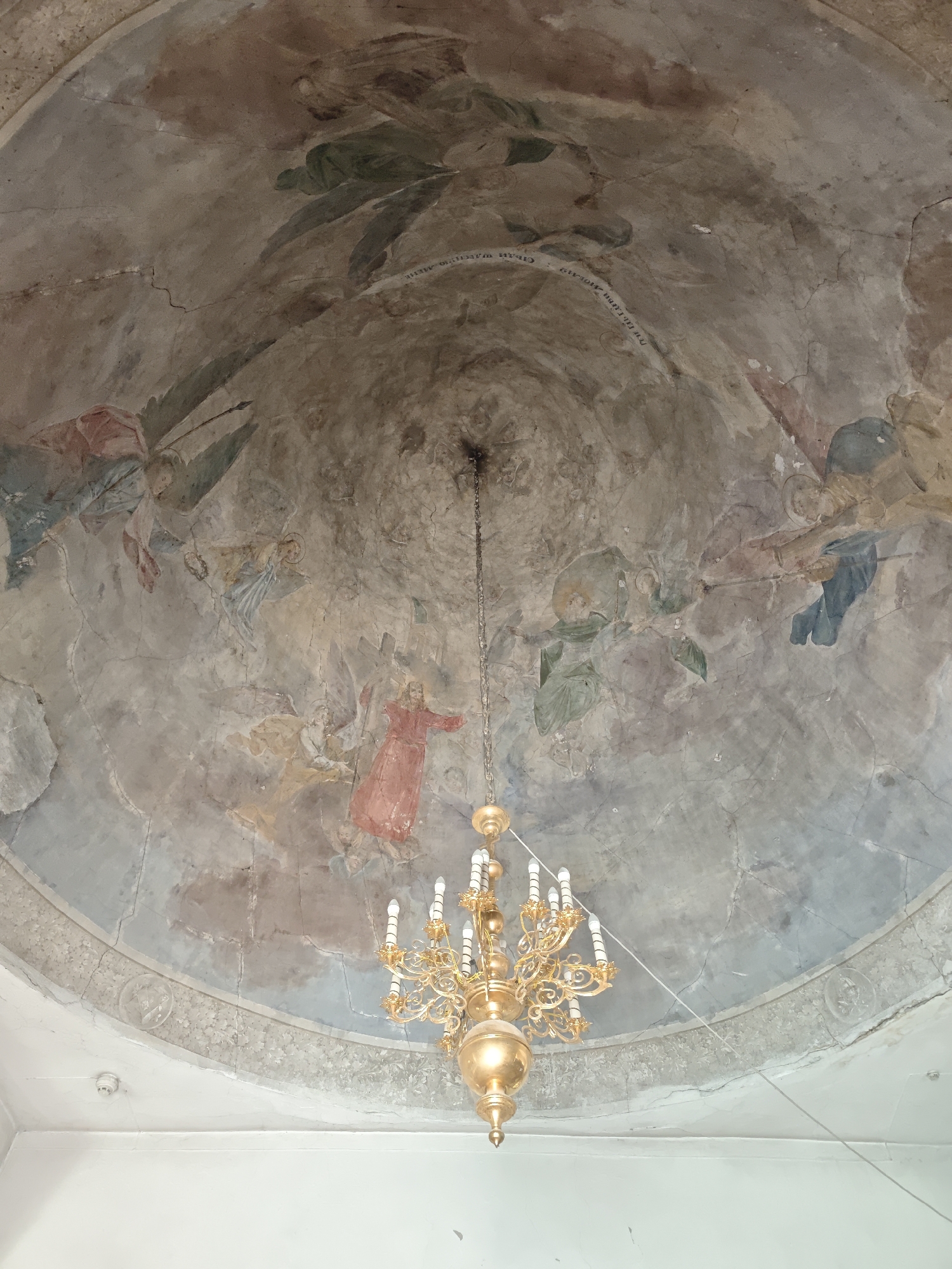The image shows the interior of a building, specifically the painted dome. The painting appears to depict religious figures, including angels and possibly Jesus Christ. The fresco appears to be old, with visible cracks and wear. A chandelier is suspended from the center of the dome. The location is likely in Selivanovo, Russia. The presence of religious iconography suggests the location might be a church or a religious building.
