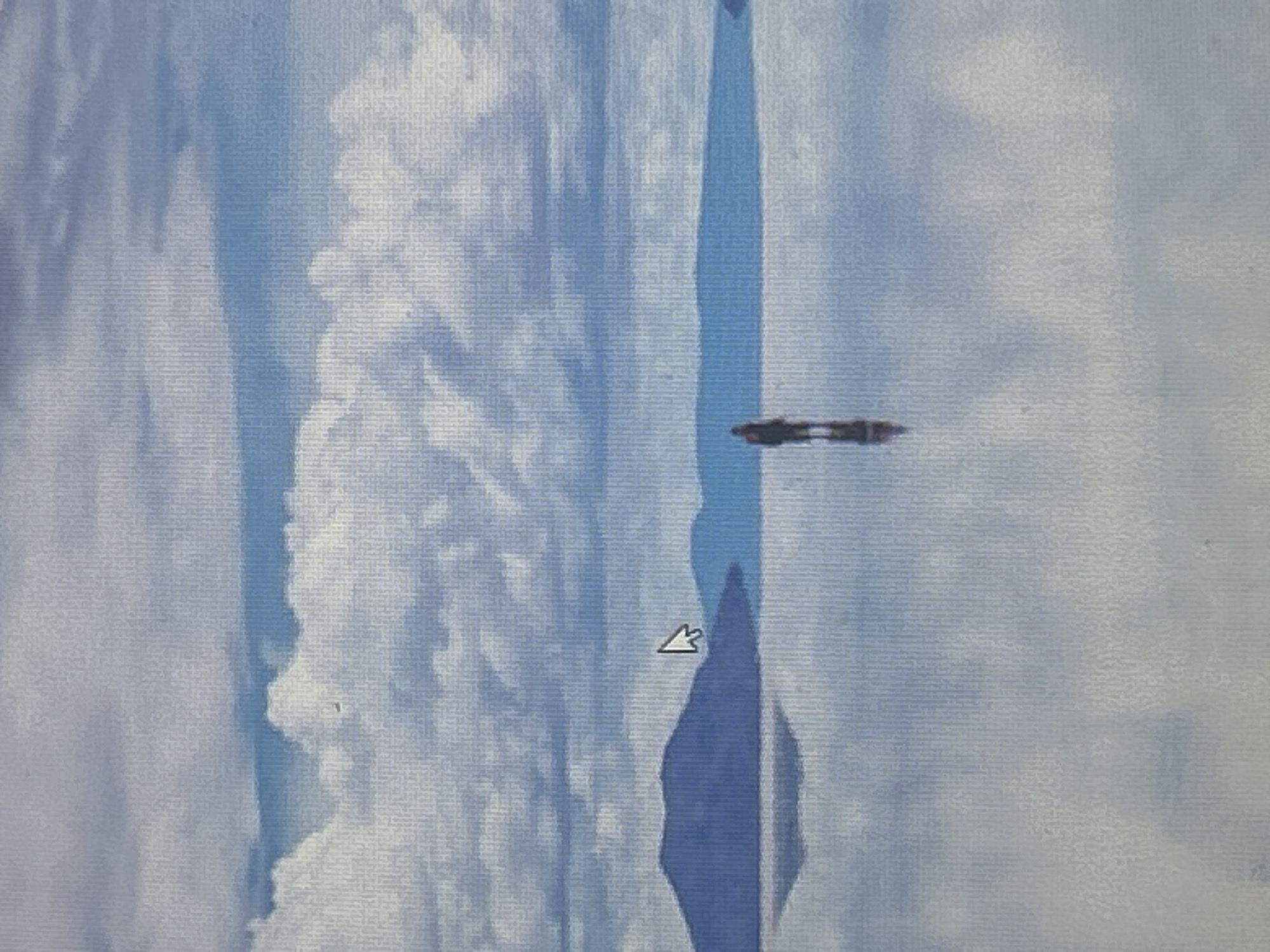 The image depicts a vast, reflective landscape under a cloudy sky. In the foreground, a person stands in the middle of a perfectly still, mirror-like surface that reflects the sky and distant mountains. The person appears to be alone, facing away from the camera. In the background, a series of low, blue-hued mountains stretch across the horizon. The sky is filled with large, white clouds against a pale blue backdrop. The overall impression is one of immense space and tranquility. The image is not located in Sofia, Bulgaria.