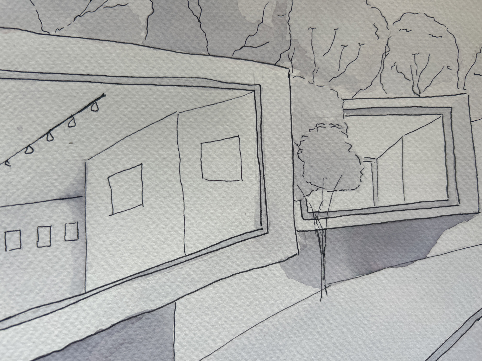 A gray-scale watercolor and ink sketch depicts two angular structures, possibly modern houses, with minimalist architectural elements. The structure on the left is more prominent, showing a recessed entrance framed by a thick border, suggesting depth. Inside the entrance, there is a string of hanging lights and a rectangular window or opening. A second window or opening is visible on the exterior wall. To the left of the entrance, a lower section with three square windows is sketched. The structure on the right is partially obscured by a small tree in the foreground and has a similar framed window revealing part of its interior. The backdrop consists of sketched trees and foliage, creating an urban or suburban environment. The illustration is executed on textured paper, with a limited value range suggesting a somber or contemplative mood.