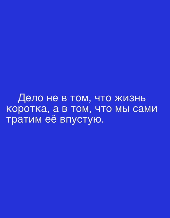 The image is a close-up, full-frame shot of a blue background with white text. The text reads: "Дело не в том, что жизнь коротка, а в том, что мы сами тратим её впустую." This translates to "It's not that life is short, but that we ourselves waste it." There are no people, objects, actions, interactions, or environmental details visible in the image. The location in Grodzisk Wielkopolski, Poland is not discernible from the image.