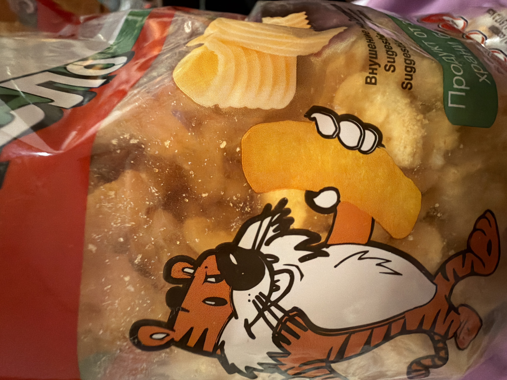 The image is a close-up of a plastic bag containing food items, possibly snacks. A cartoon tiger character is printed on the bag, holding a piece of food. The background is blurred and appears to be indoors. There is text in Cyrillic script on the bag, indicating it is a food product. The image does not contain any information about a specific location in Sofia, Bulgaria.