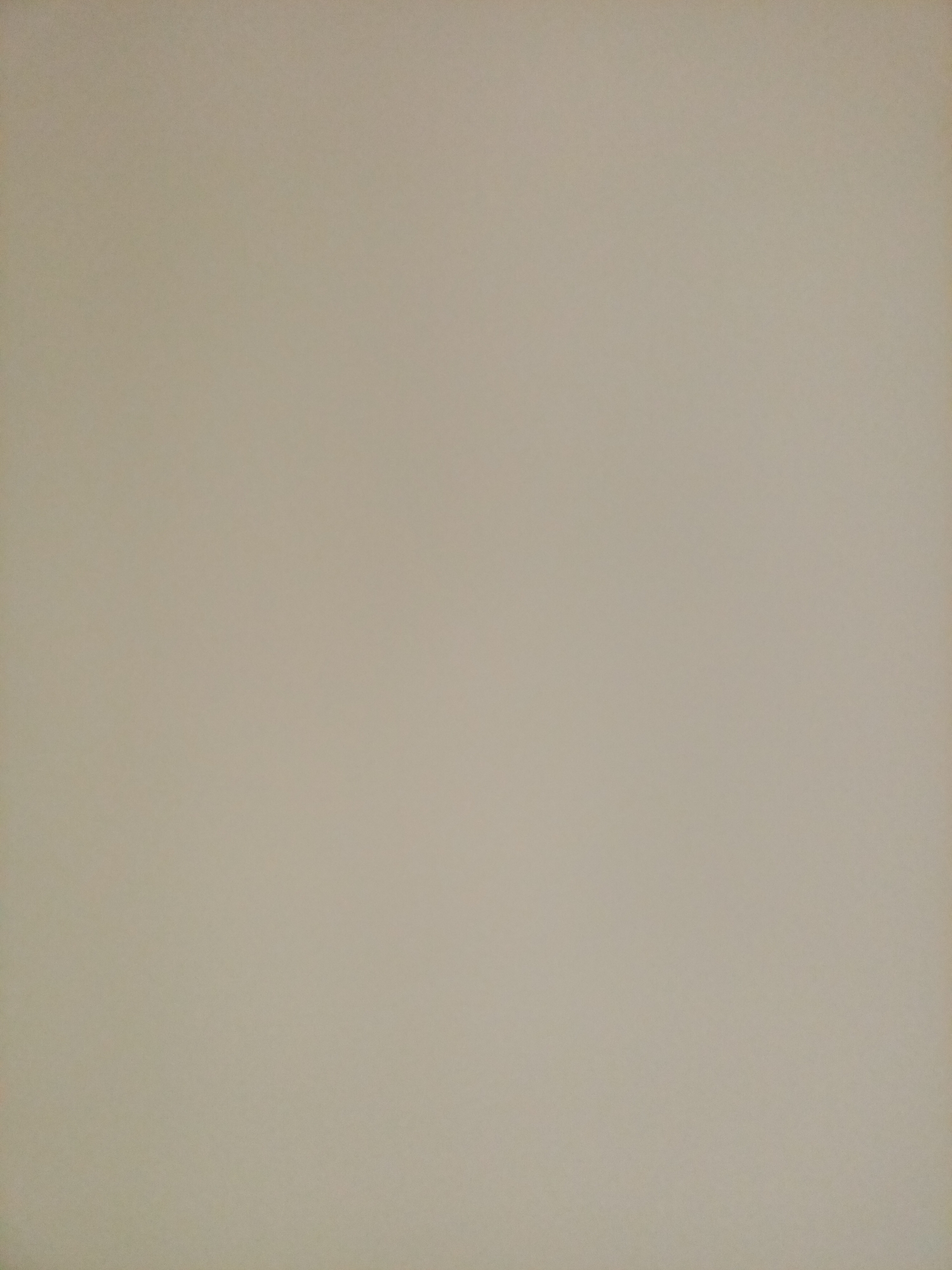 The image is a plain, textured background. The color appears to be a muted beige or light tan, with subtle variations in shade that suggest a matte surface. There are no discernible objects, people, or any specific environmental details visible. The lighting is even across the entire frame, with no strong shadows or highlights. The texture appears consistent, suggesting it could be a wall, paper, or fabric. There is no information in the image to indicate a location in Rostov-on-Don, Russia, or any specific scene.