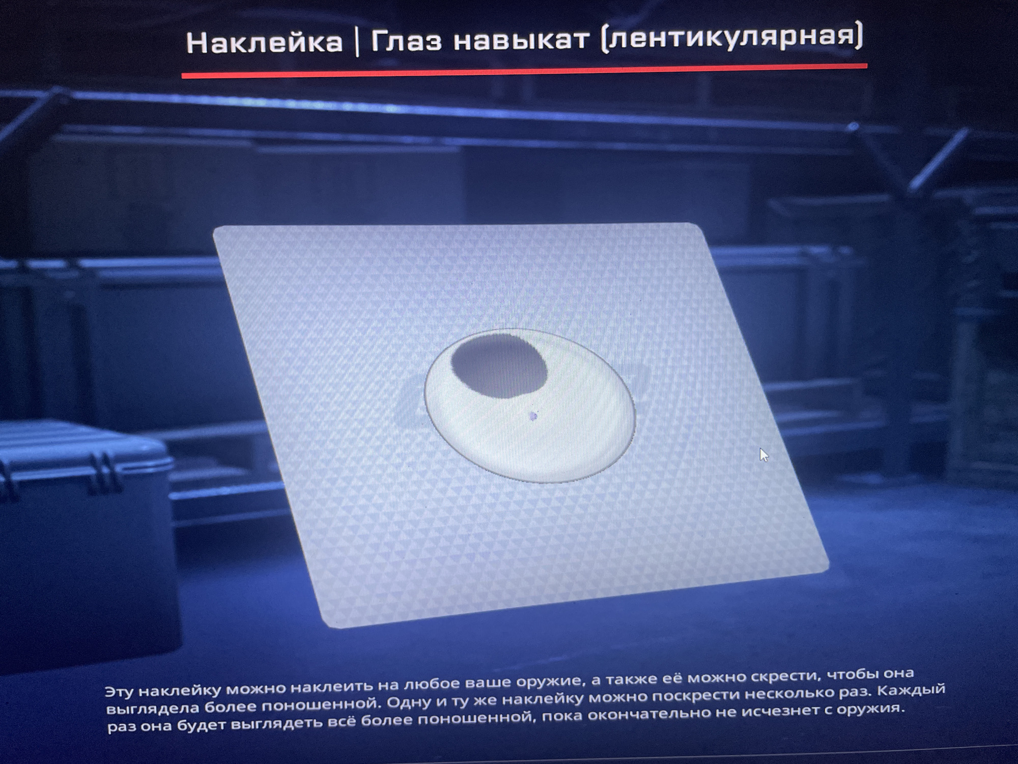 The image shows a digital interface with a large, square decal displayed prominently in the center. The decal is white with a subtle textured pattern and features a circular graphic in the middle resembling an eye. The text above the decal reads "Нашивка | Глаз навыкат (лентикулярная)", which translates to "Patch | Glaz navikat (lenticular)". Below the decal, there is Russian text describing the functionality of the decal. The background appears to be a dark, possibly game-like environment with a blueish tint. The scene is not located in the city of Kołobrzeg, Poland, but rather appears to be from a video game or a digital application.