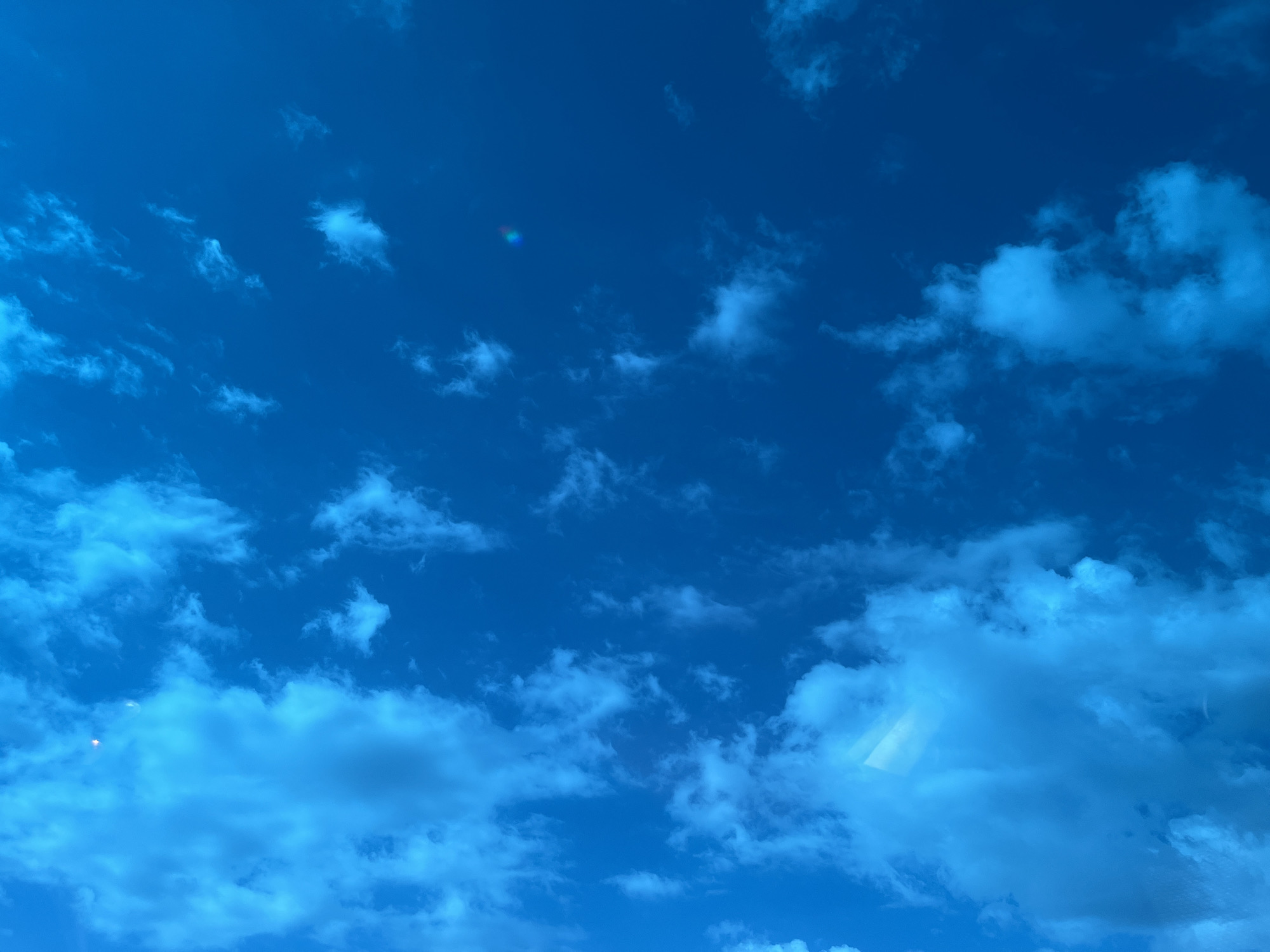 The image shows a blue sky with scattered white clouds. There is no evidence to indicate this image was taken in Tlustenkhabl, Russia. No people, actions, or interactions are depicted.