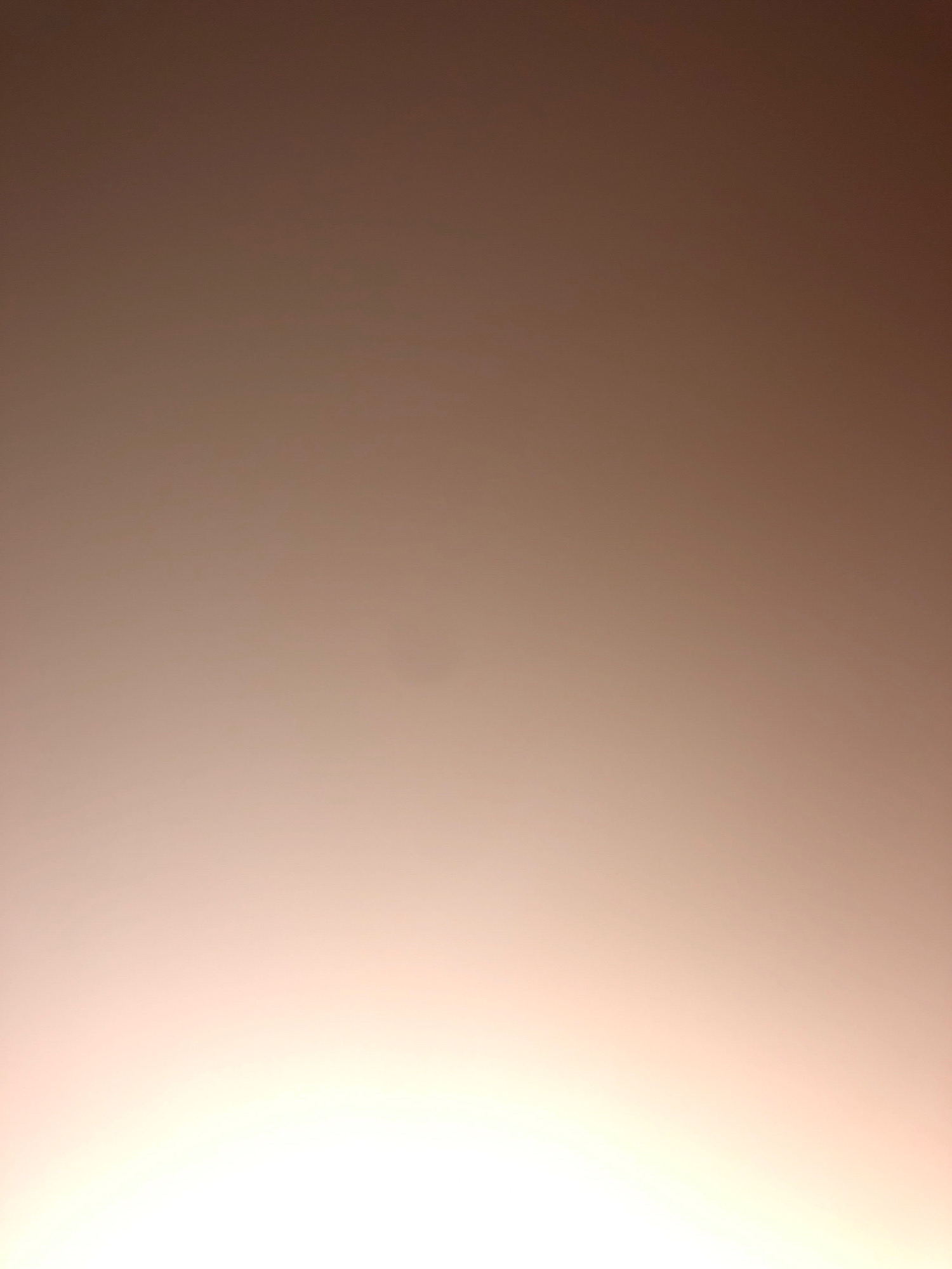 The image is a poorly lit, out-of-focus photograph with a gradient of colors ranging from dark brown at the top to bright white at the bottom. There are no discernible people, subjects, objects, actions, interactions, or environmental details visible in the image. The scene appears to be an abstract or accidental capture, with no identifiable features to pinpoint a location in Peshawar City Tehsil, Pakistan, or any other location.