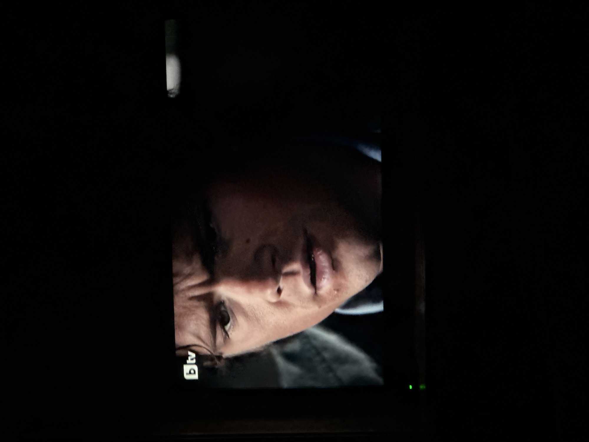 Close-up of a man's face on a television screen. The man has light skin, dark hair, and is looking downwards. The BTV logo is visible in the lower left corner. The screen appears to be in a darkened room. It is not possible to determine if this image is related to the city of Sarnevo, Bulgaria.