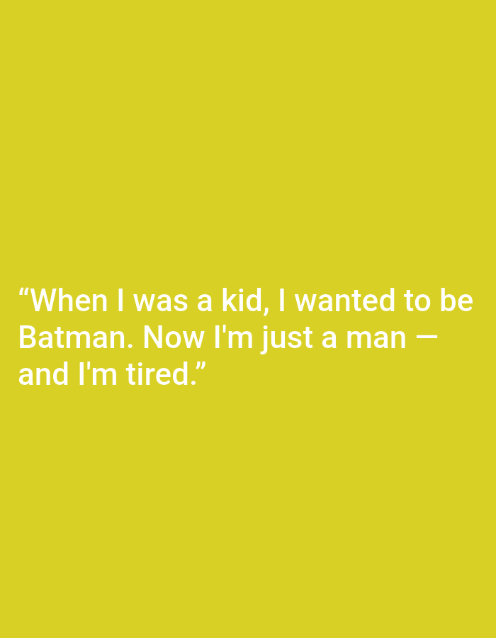 This media file is a close-up, medium shot of a bright yellow background with white text. The text reads: "When I was a kid, I wanted to be Batman. Now I'm just a man – and I'm tired." The text is centered on the screen. There are no people, objects, or any scene details visible, only the text against the solid yellow background. The emotions conveyed by the text are a sense of disillusionment and weariness. The location context of Kępno, Poland is provided, but there are no visual cues within the image to support this.