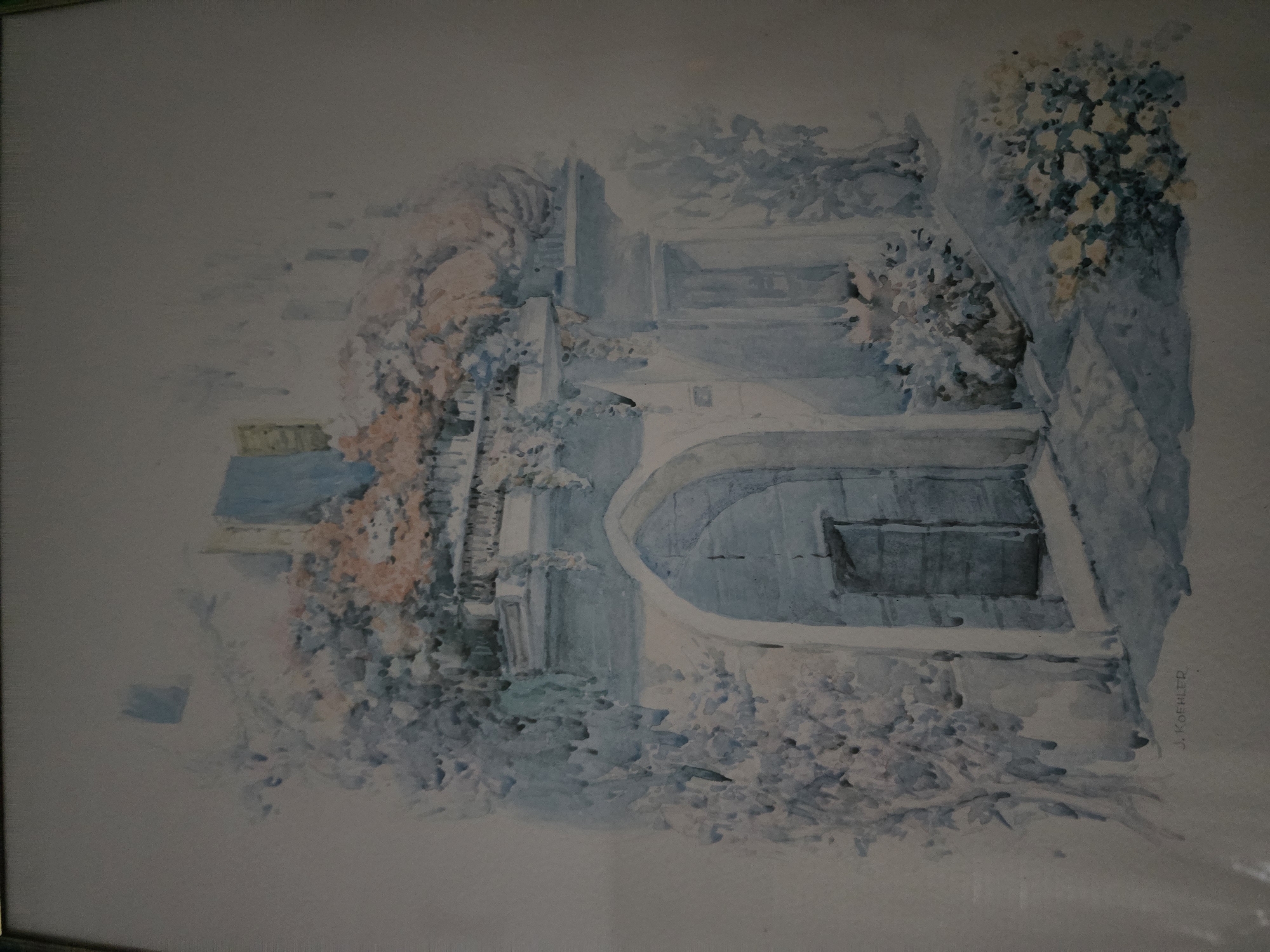 A watercolor painting depicts a doorway in a building, surrounded by lush greenery and flowers. The architectural style suggests an older European setting. The doorway is arched and leads into a dark interior. Above the doorway, a balcony is adorned with plants and flowers in shades of pink and white. The overall impression is one of a tranquil and picturesque scene. The artist's signature, "J. KOEHLER," is visible in the lower left corner. This painting is believed to be a depiction of a location in the city of Mutzig, France.