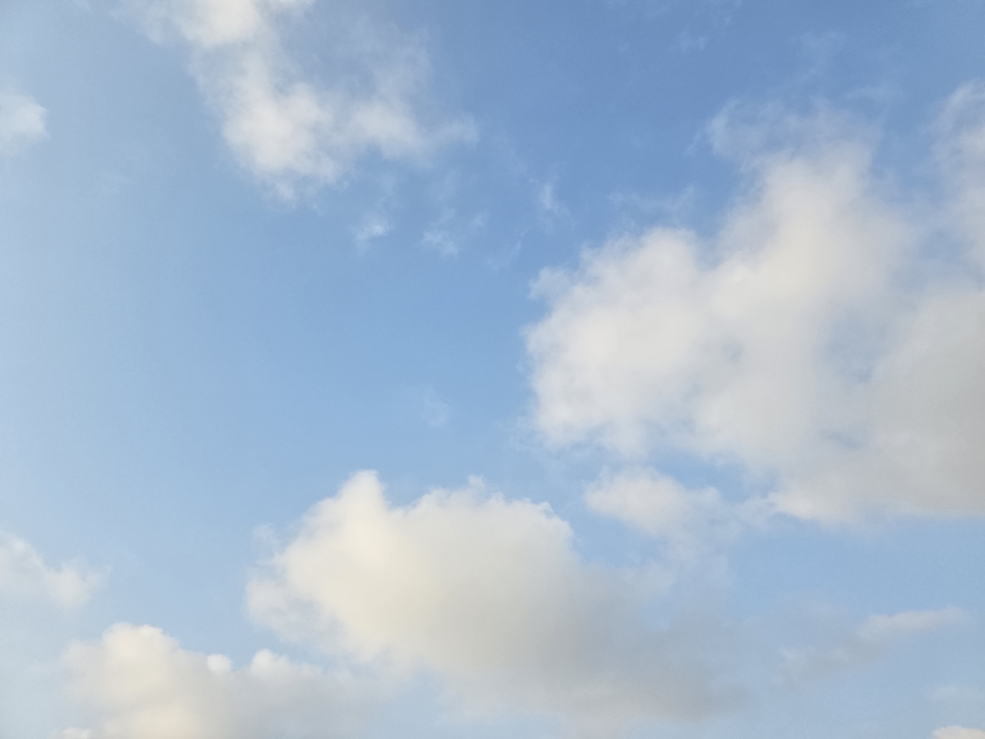 The image depicts a clear blue sky with scattered white clouds. There are no people, subjects, objects, actions, or interactions visible in the image. The environment is solely the sky. The location in Ashkelon, Israel, is not determinable from the visual content of the image.