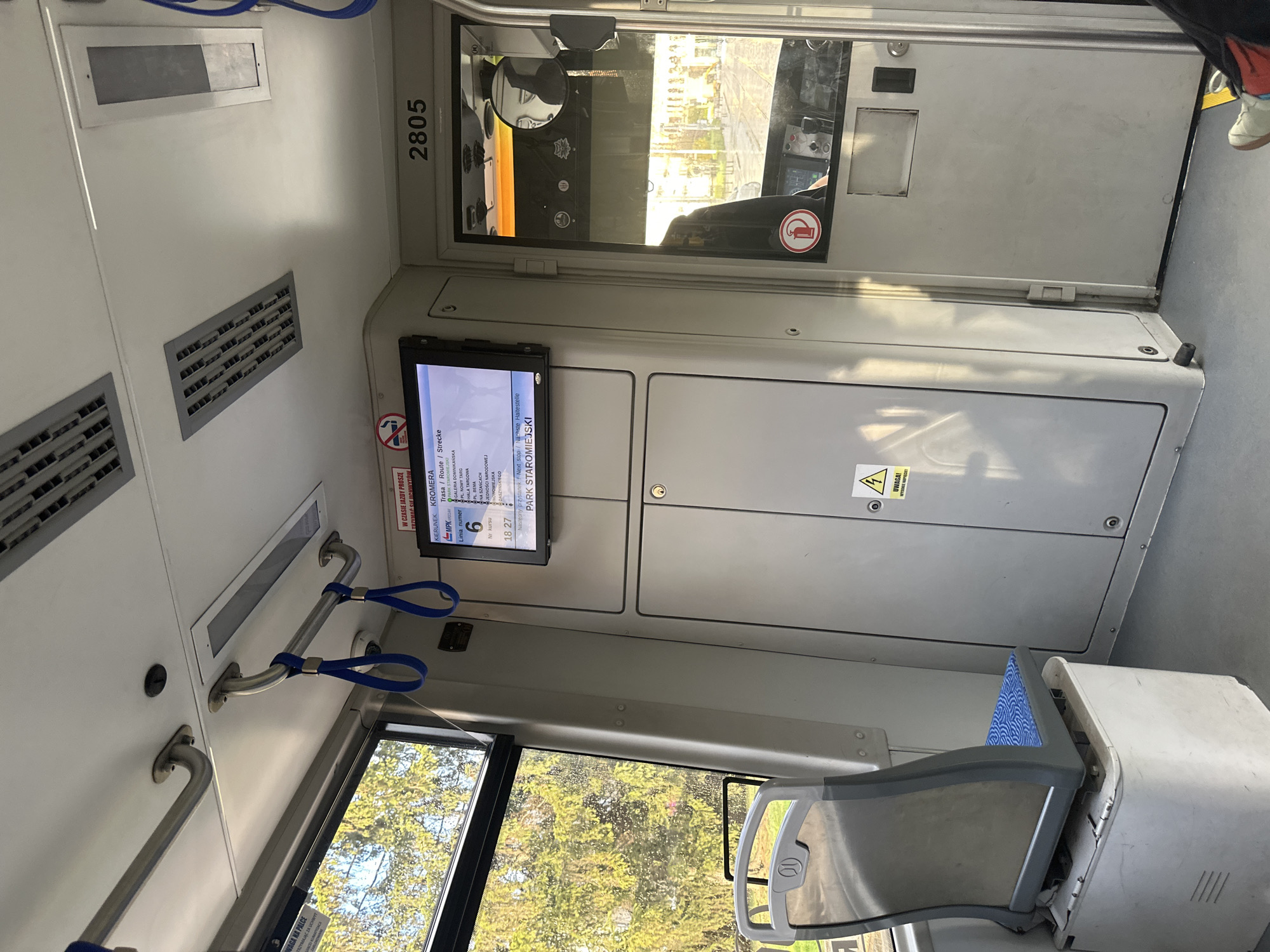 The image shows the interior of a tram in Wrocław, Poland. The tram is line number 6 and is heading in the direction of Kromera. The next stop is Park Staromiejski. The number 2805 is on the wall above the driver's area. A seat is visible on the right side of the image. Metal handrails are mounted on the wall.