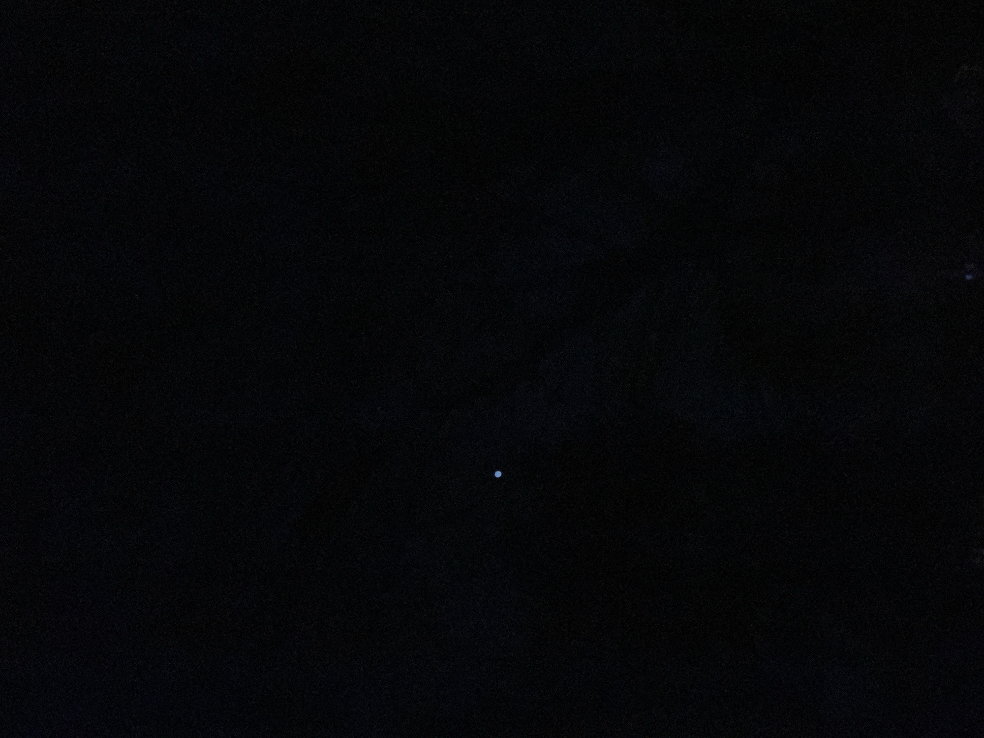 A small, white dot is visible in the lower center of the image against a dark, almost black, background. The scene is unidentifiable in the City of Newburgh, United States of America. No people, subjects, objects, actions, interactions, or environmental details are discernable beyond the single white dot.