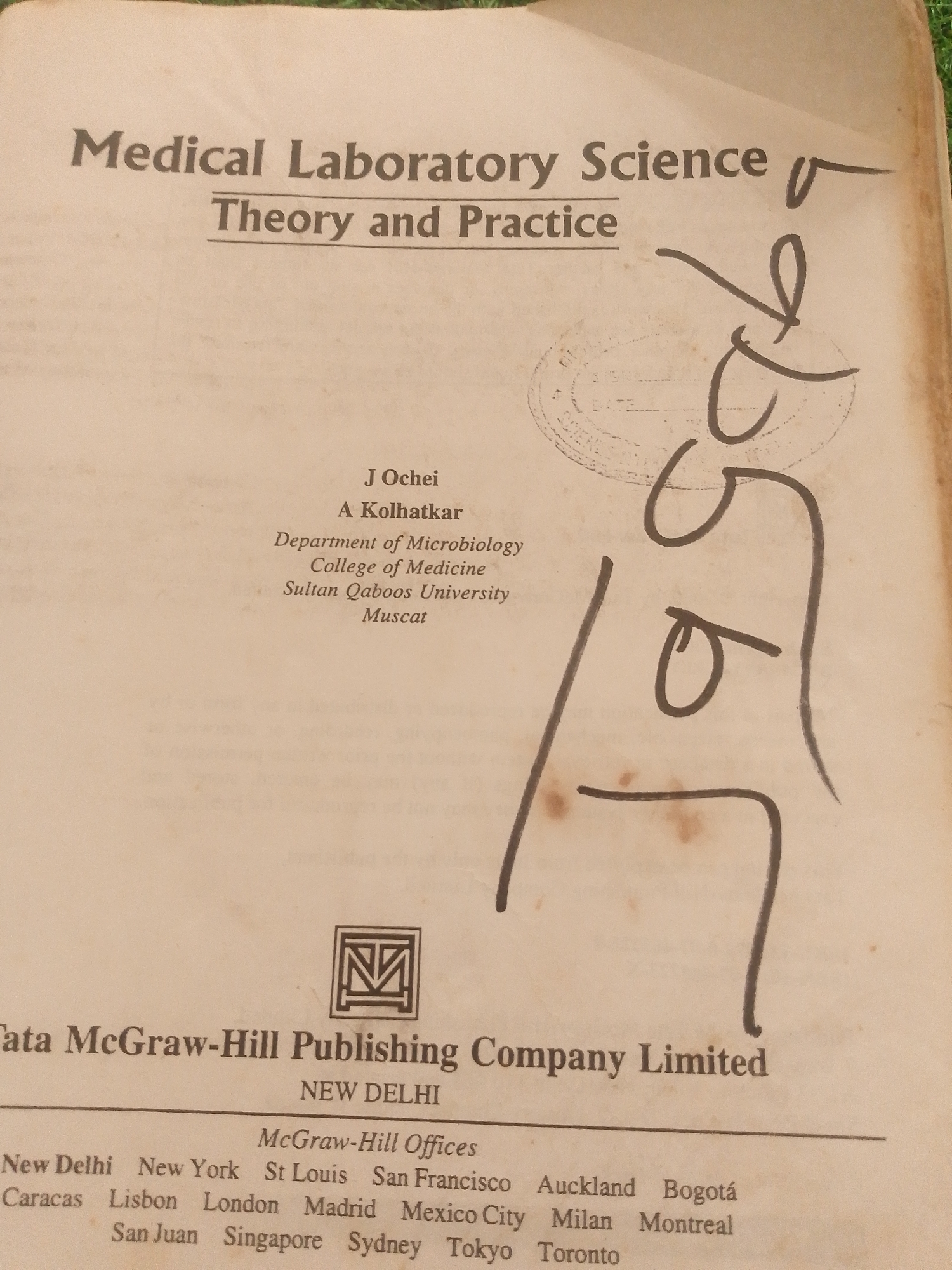 This is an image of the cover page of a book titled "Medical Laboratory Science: Theory and Practice." The book is authored by J. Ochei and A. Kolhatkar, who are affiliated with the Department of Microbiology, College of Medicine, Sultan Qaboos University, Muscat. The publisher is Tata McGraw-Hill Publishing Company Limited, with offices listed in New Delhi and various international locations, including New York, St. Louis, San Francisco, Auckland, Bogotá, Caracas, Lisbon, London, Madrid, Mexico City, Milan, Montreal, San Juan, Singapore, Sydney, Tokyo, and Toronto.
The page appears aged, with a slightly yellowed tint and some brown spotting. There are also some handwritten markings on the right side of the page, appearing to be numbers or scribbles in dark ink. The layout is typical of a book cover, with the title prominently displayed at the top, followed by the author(s) and their affiliations, and finally the publisher information at the bottom. The book's contents are focused on medical laboratory science, suggesting a subject matter related to healthcare, diagnostics, and scientific research. The presence of multiple international locations for the publisher indicates a global reach for the book. There are no discernible cues about the time of day, weather, or emotions conveyed by the image itself.