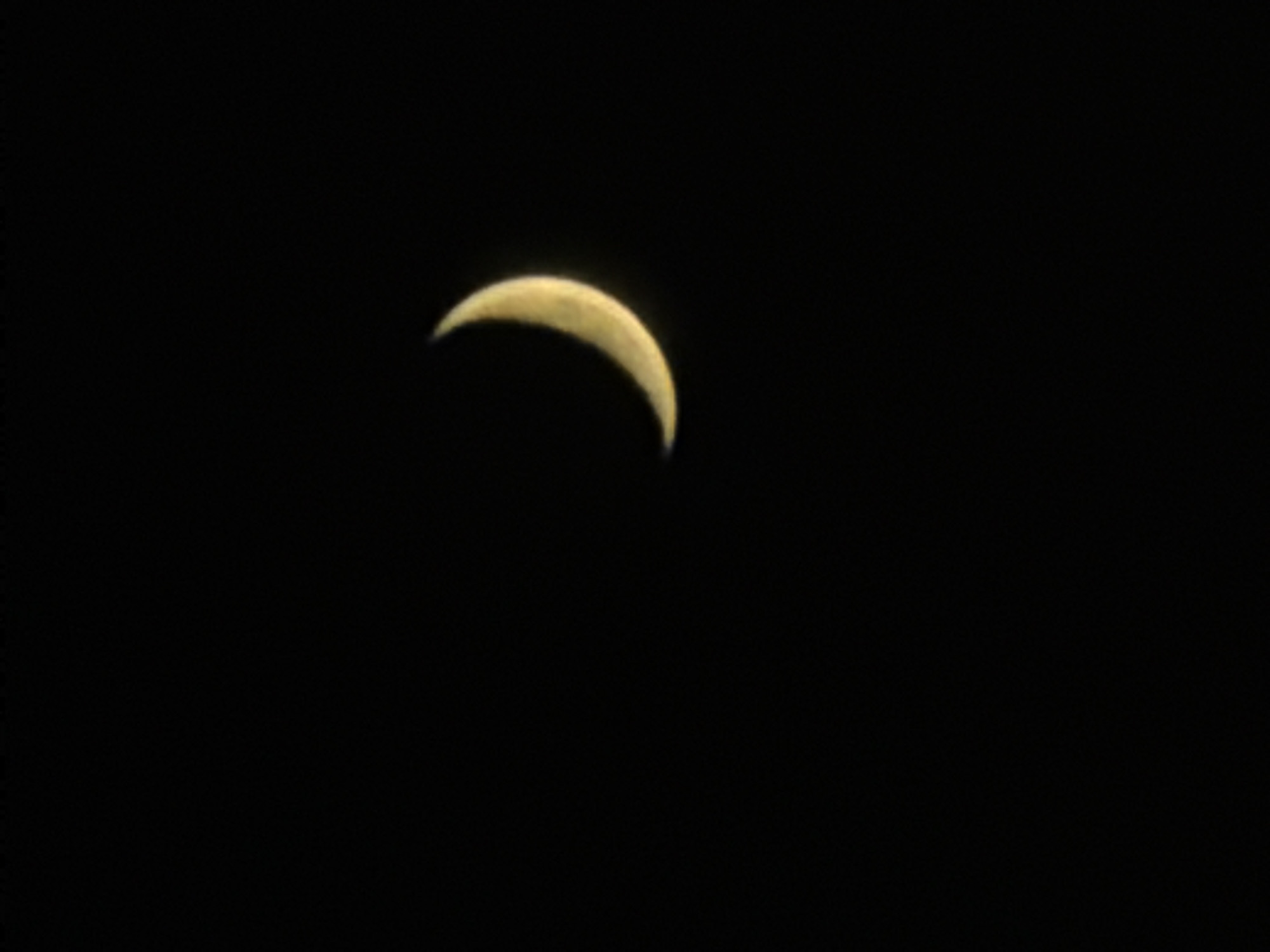 A crescent moon is visible against a black sky. The moon is in the upper right quadrant of the image and is illuminated on its right side, casting a soft glow. The rest of the image is dark, with no other celestial bodies or objects visible. There is no indication of any location in Arbanassi, Bulgaria, as the image only contains the moon and the night sky.