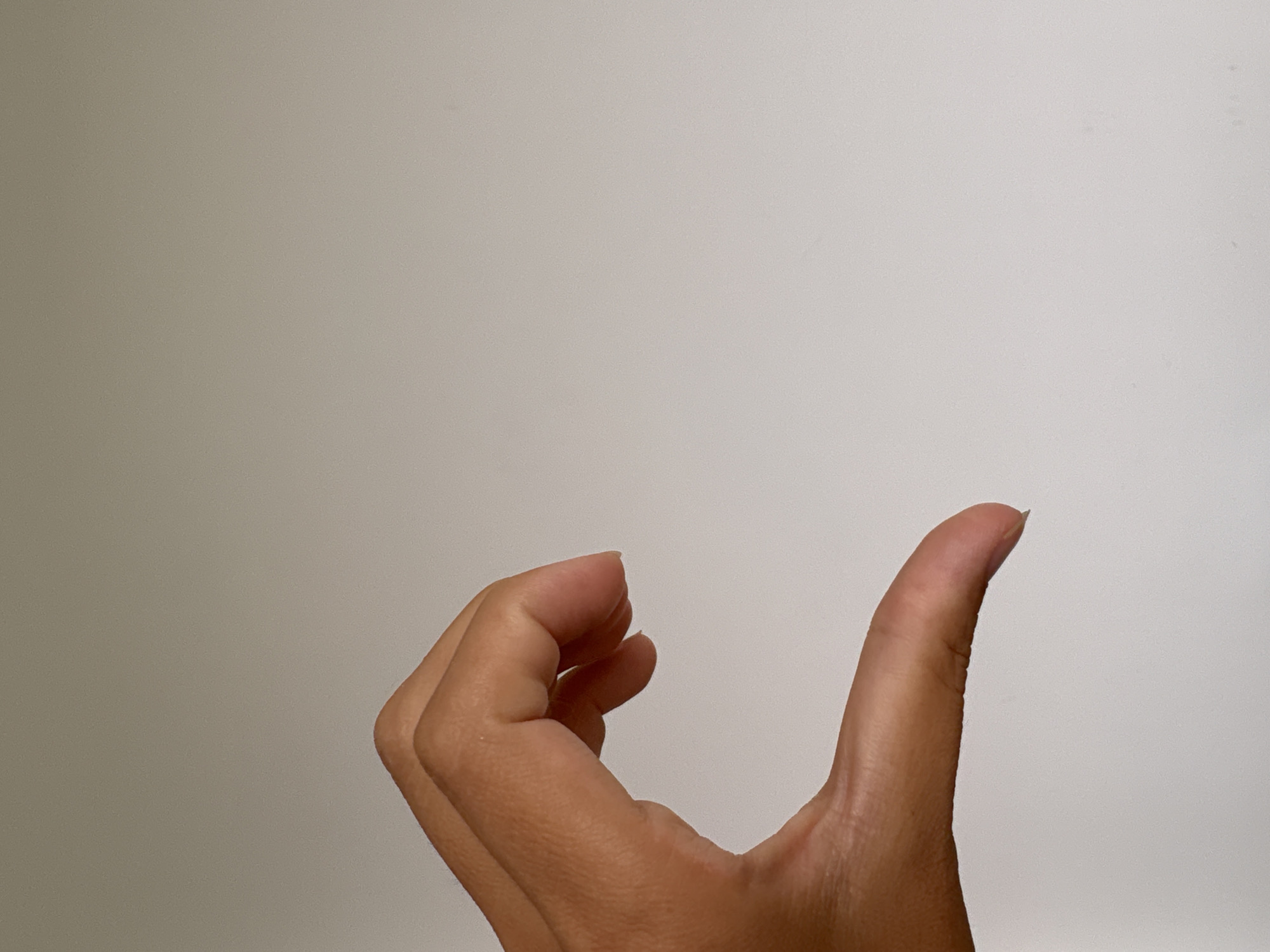 A hand is visible in the lower half of the frame against a plain, light-colored background. The thumb is extended upward. There is no indication of the location being in Ембаево, Russia.