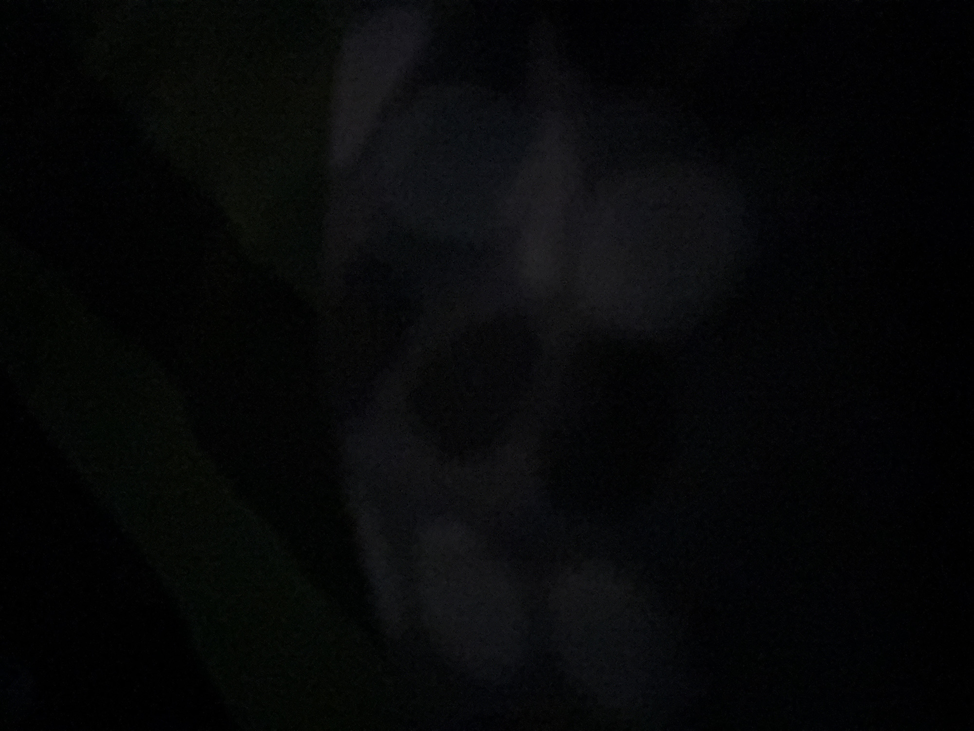 The image is very dark and blurry, making it difficult to discern details. However, there appears to be a soccer ball visible in the center. There is a dark background. It is difficult to determine the location in Yerevan, Armenia, or any other details about people, subjects, actions, interactions, and the environment.