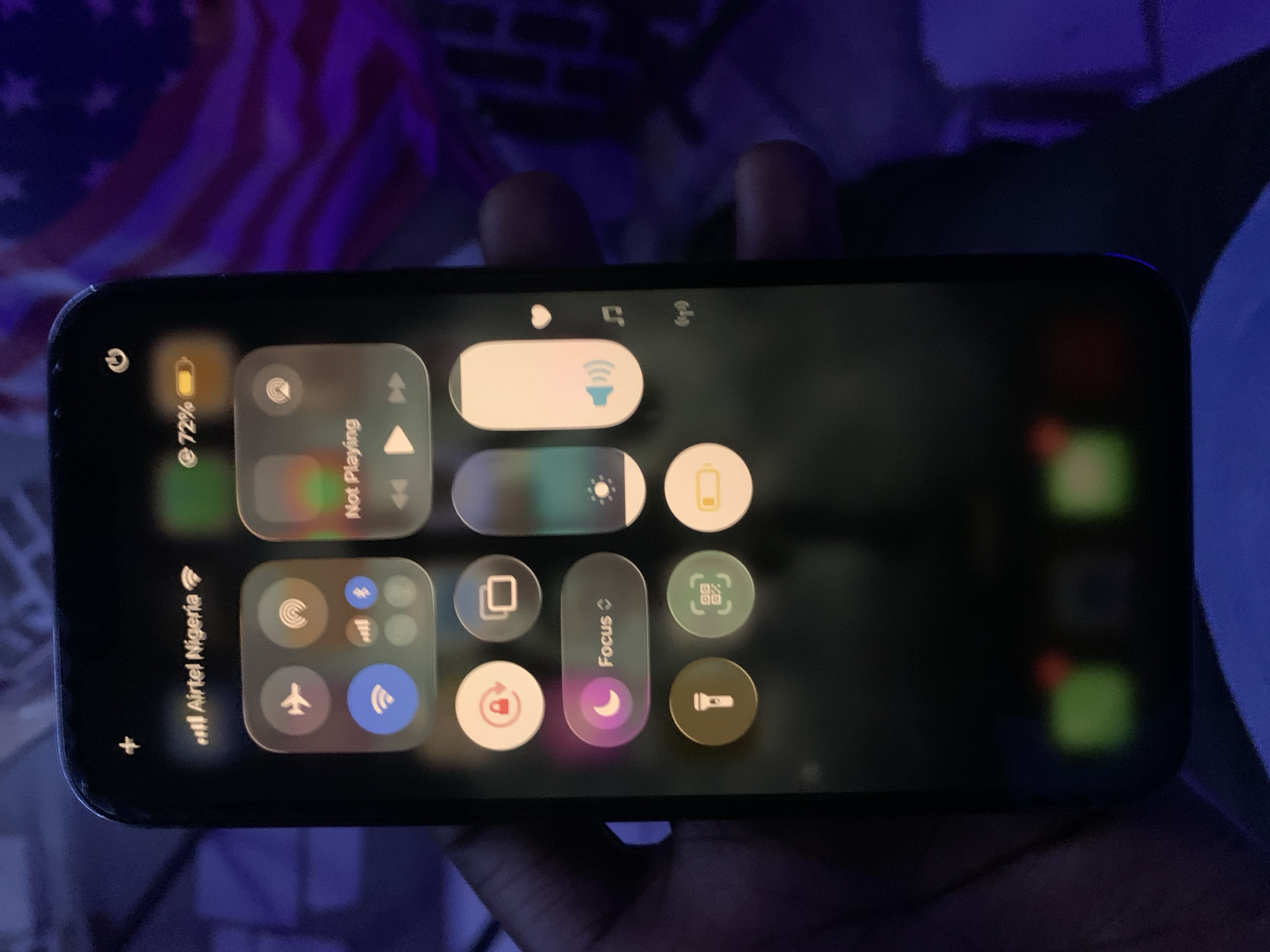 A close-up image displays an iPhone screen displaying the control center. The phone's battery is at 72%, and the Wi-Fi is connected to an Airtel Nigeria network. The location in the city of New Stadium, Nigeria is not contained in the image.
