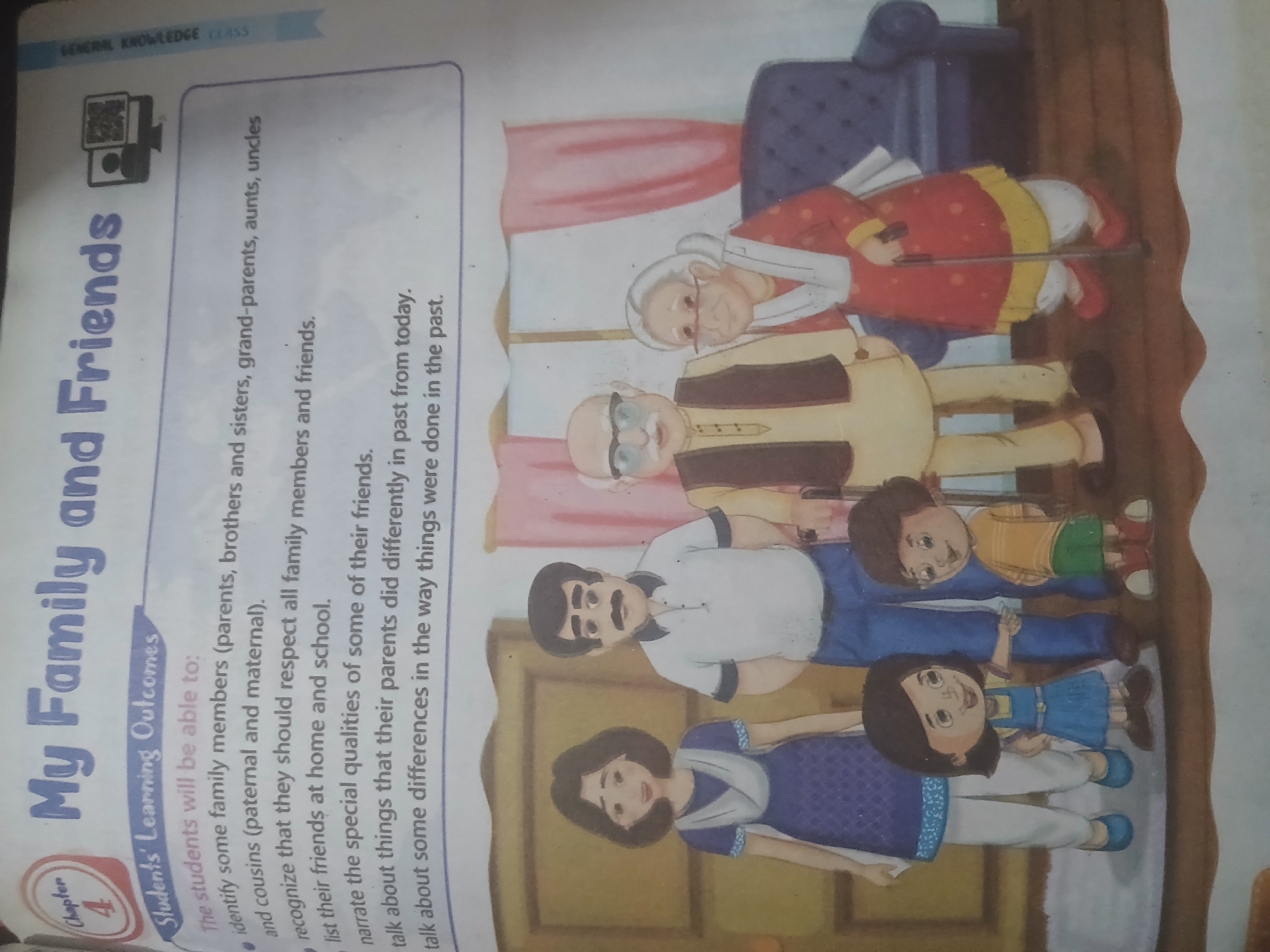 The image displays a page from a textbook or educational material. At the top, a chapter title "My Family and Friends" is prominently displayed in blue, block letters. Below this, a section titled "Students' Learning Outcomes" is presented, followed by a bulleted list of learning objectives. The list includes phrases like "identify some family members," "recognize that they should respect all family members," "list their friends at home and school," "narrate the special qualities of some of their friends," and "talk about things that their parents did differently" and "talk about some differences in the way things were done in the past."
The lower portion of the image features an illustration of a family. There are six people depicted: a woman and a man standing together, and behind them, an older man and an older woman. In front of the adults are two children, a girl and a boy. The family members are all drawn in a cartoonish style with bright colors and simple features. They appear to be indoors, with a plain background and a couch visible on the right side.
The image's context suggests an educational setting for young learners, focusing on social studies or personal development. The absence of any specific landmarks or city-specific elements in the visual content makes it impossible to determine its location within Peshawar City Tehsil, Pakistan, or any other specific geographical area. The description is purely based on the visual elements present in the image.